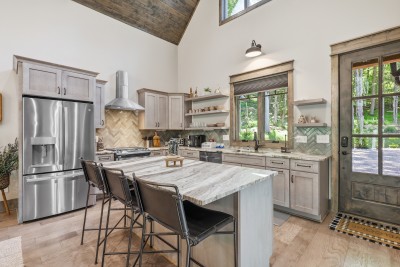 Designer kitchen featuring forest views and spacious island seating — a bright, stylish space perfect for cooking, gathering, and enjoying meals with a stunning natural backdrop.