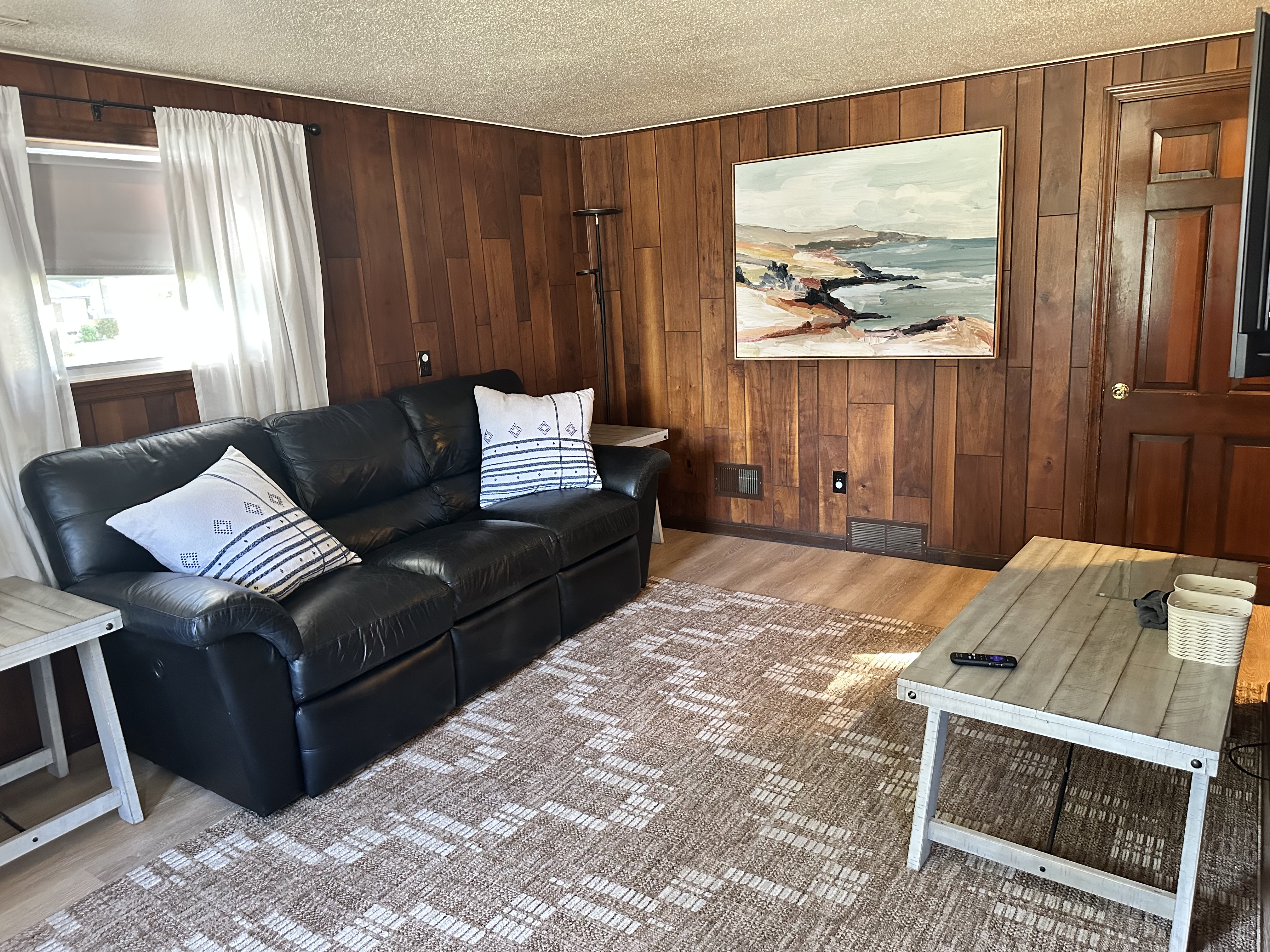 Cozy wood-paneled living room with natural light and comfy seating