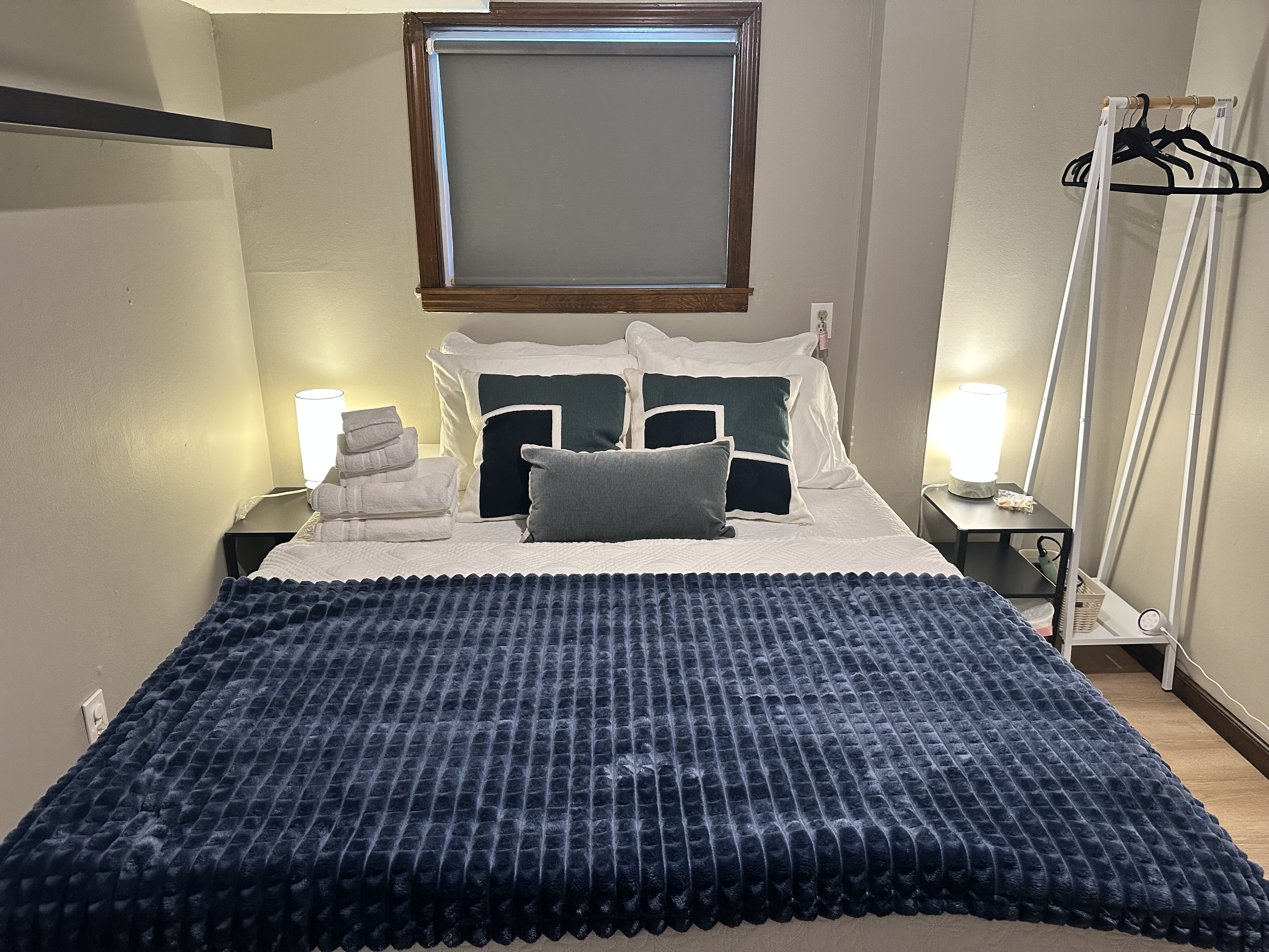 Cozy bedroom with plush bedding, soft lighting, and handy guest storage