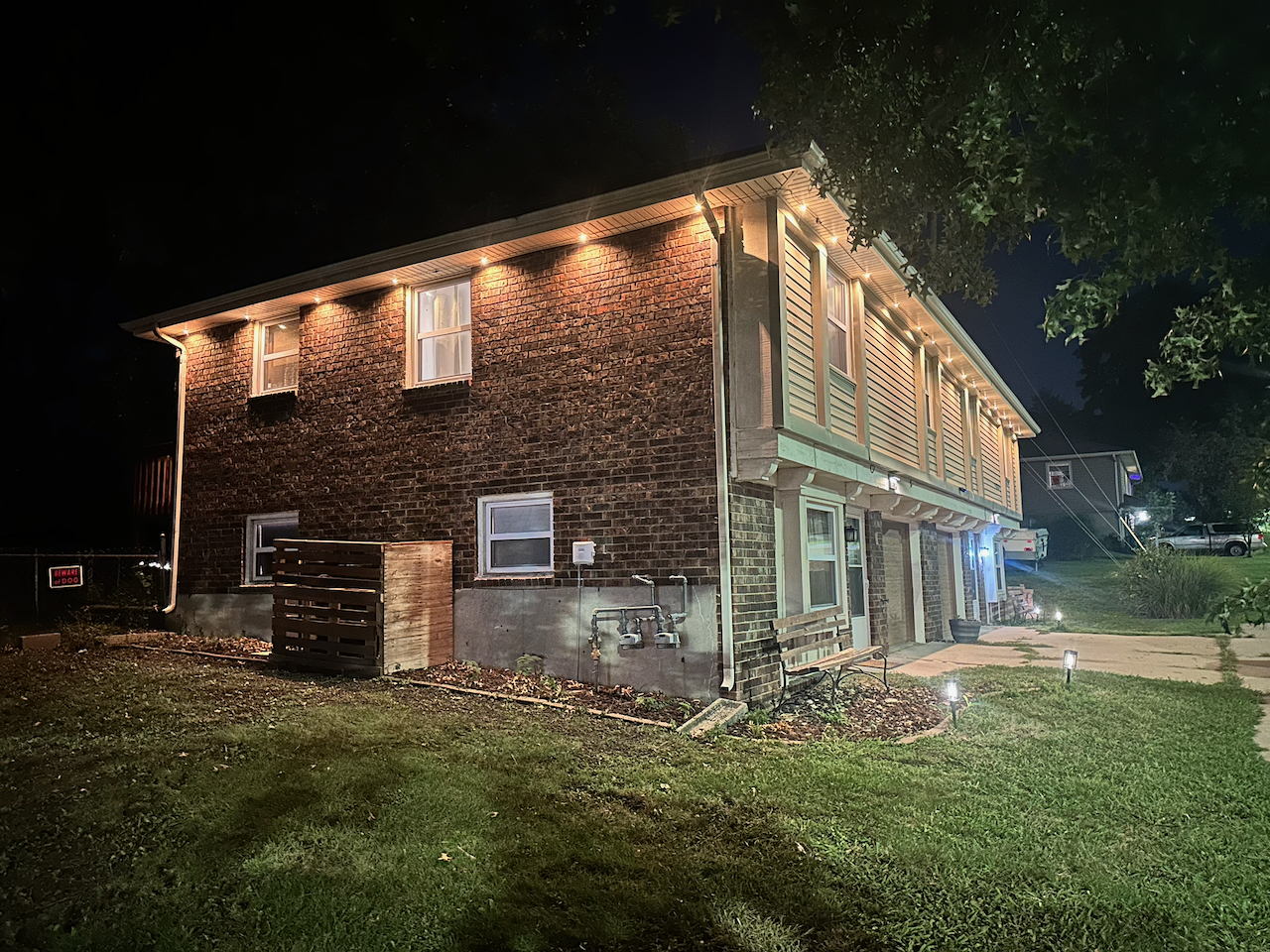 Welcoming brick exterior with warm lighting and landscaped entry