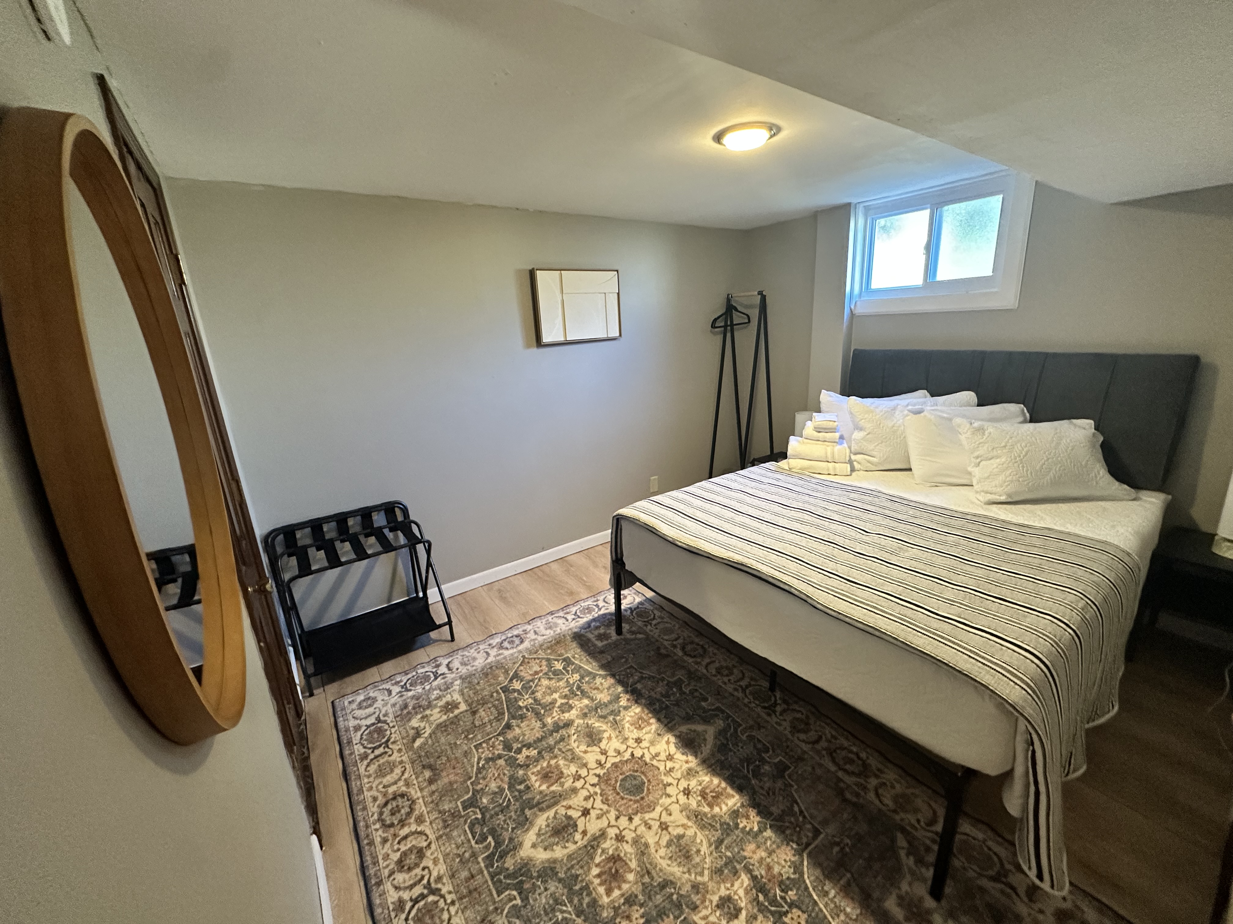 Cozy queen bedroom with natural light and thoughtful guest amenities