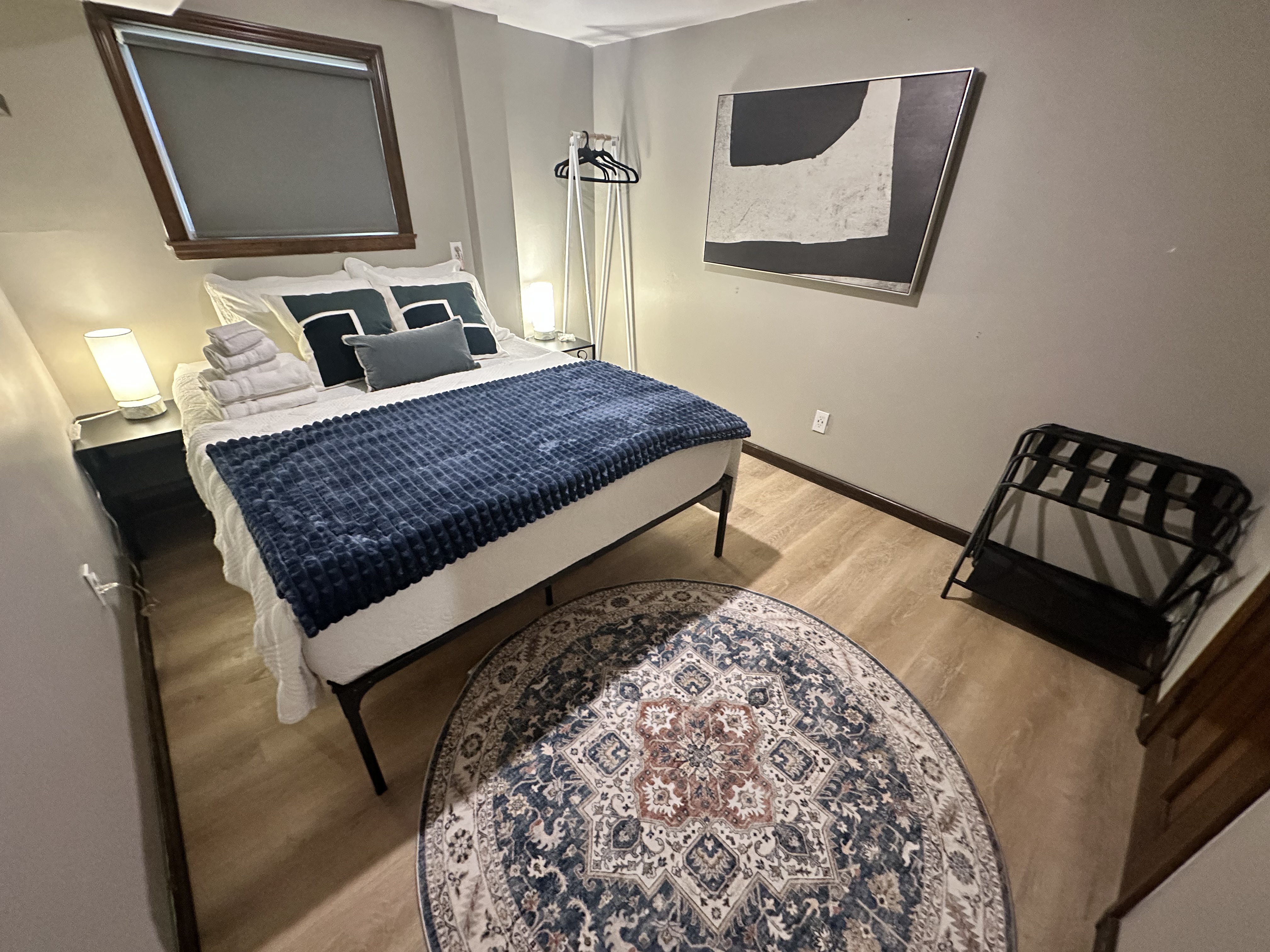 Cozy modern bedroom with plush bedding, warm lighting, and guest-friendly touches