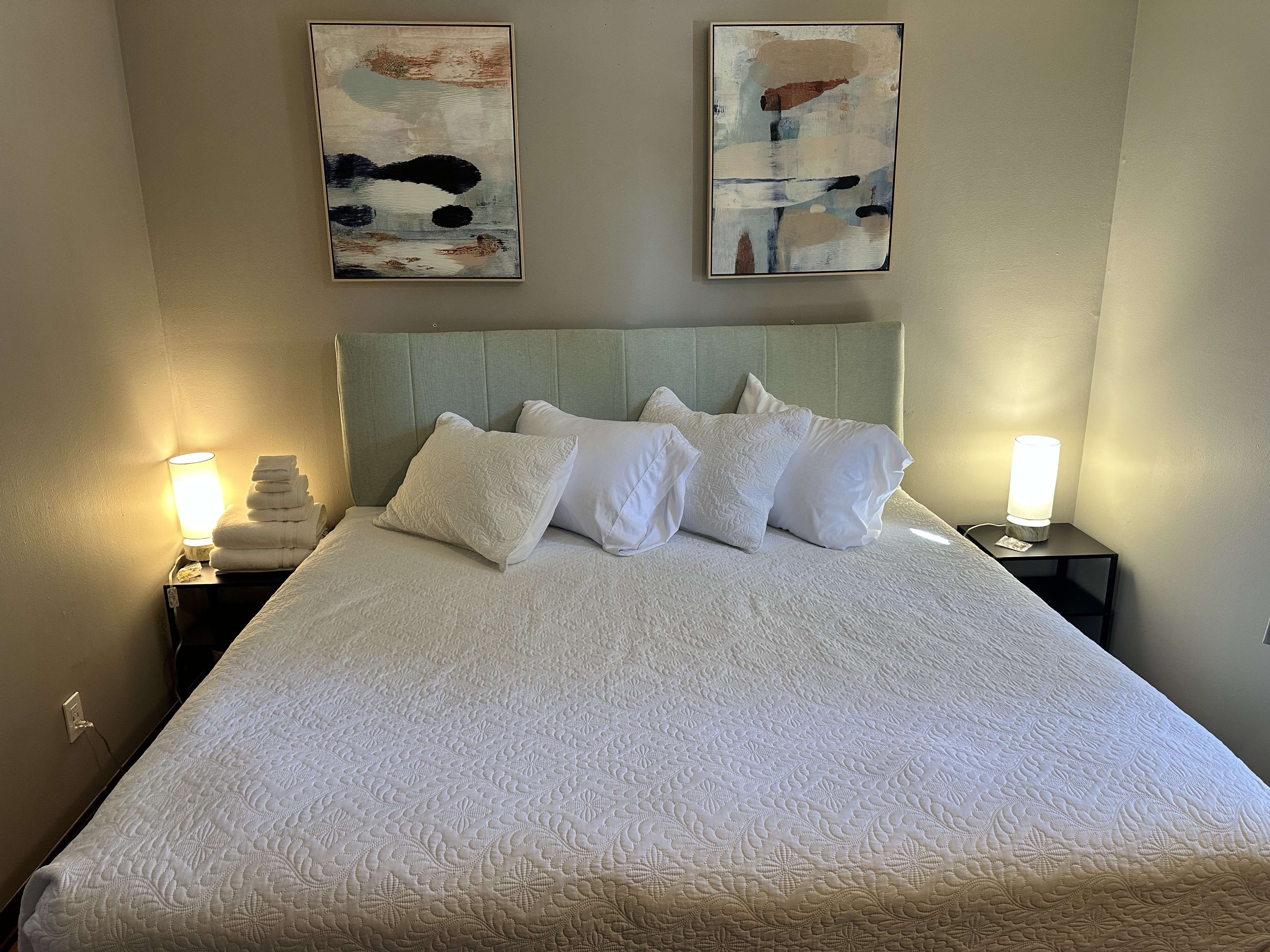 Cozy, guest-ready bedroom with warm lighting and plush king bed