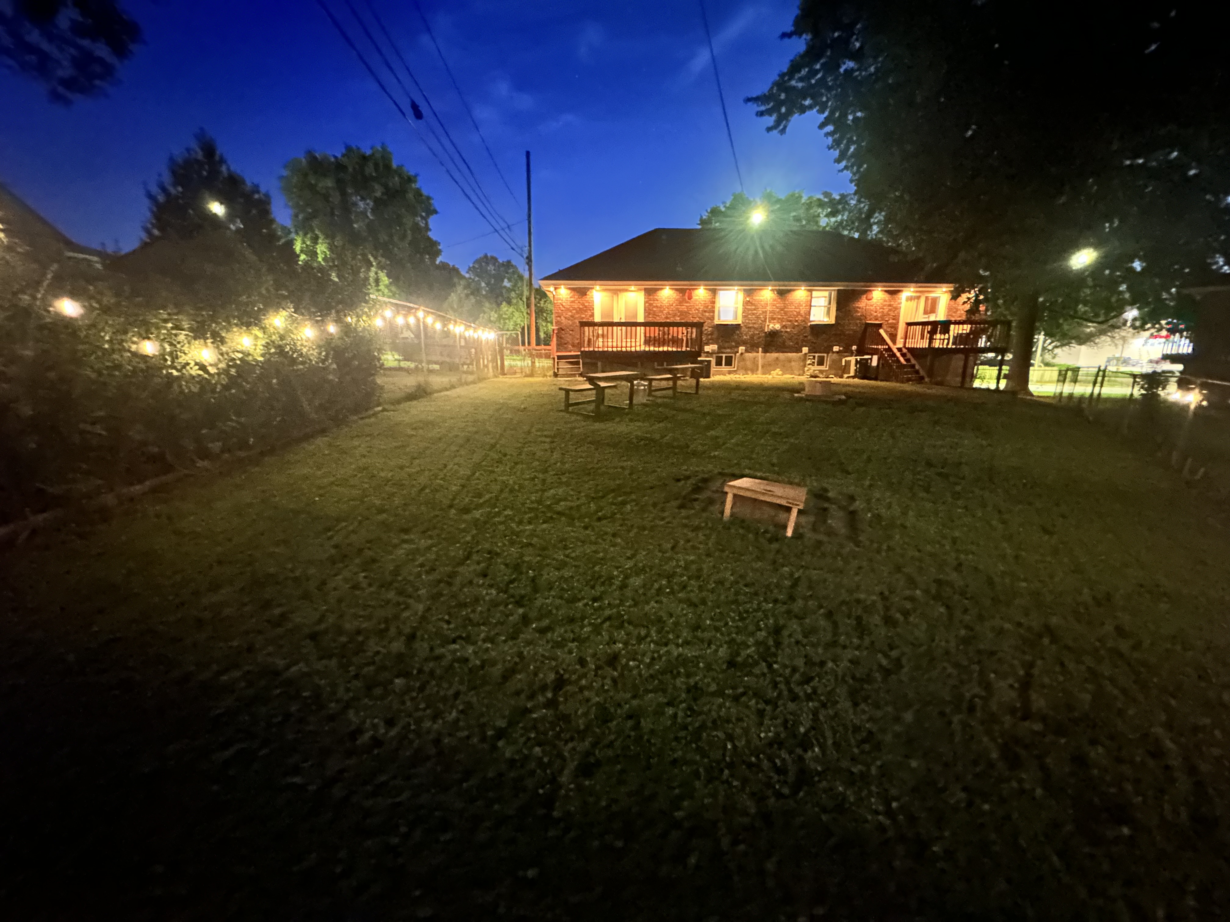 Spacious backyard with string lights, deck seating, and room to unwind