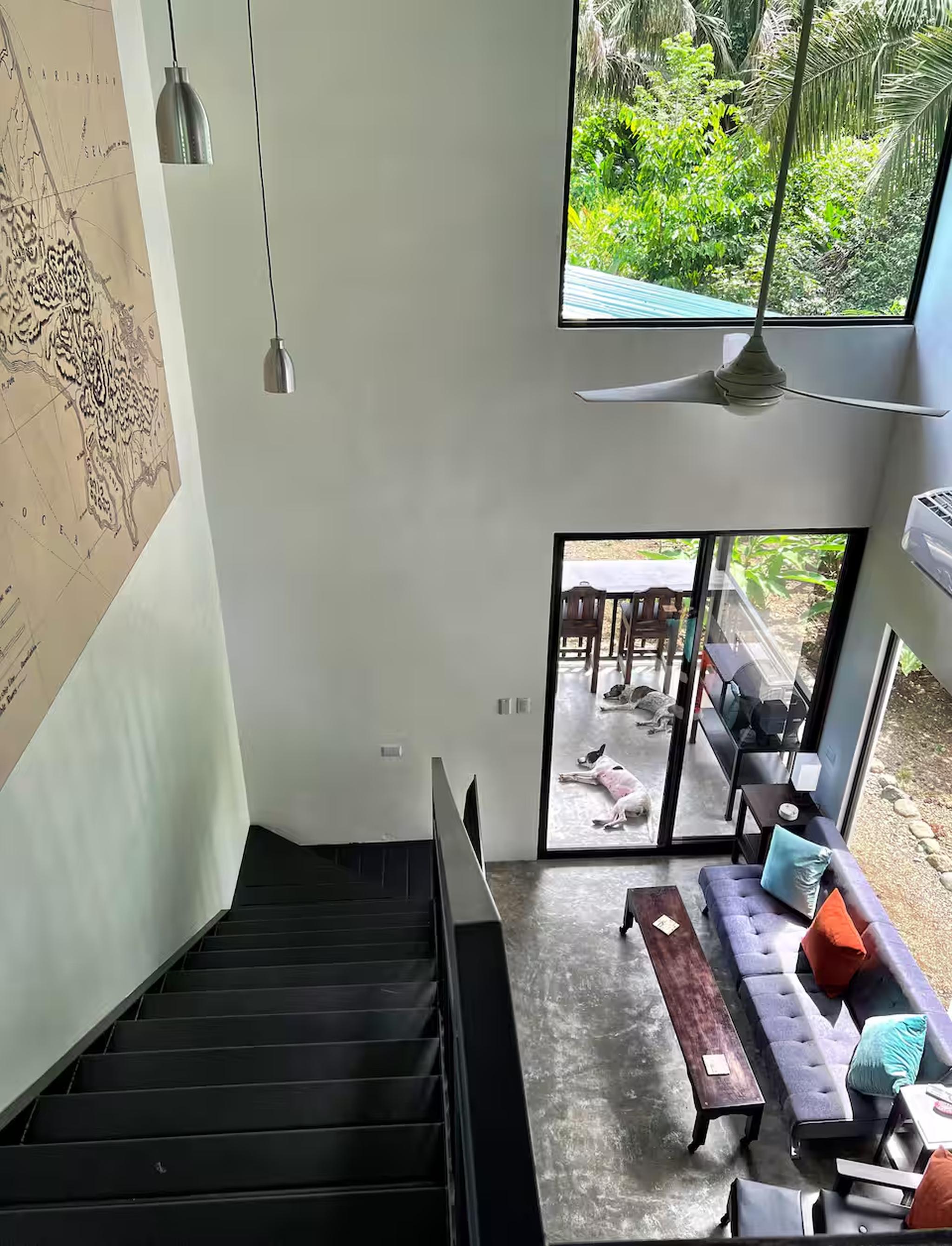Airy loft-style living room with patio access and lush tropical views