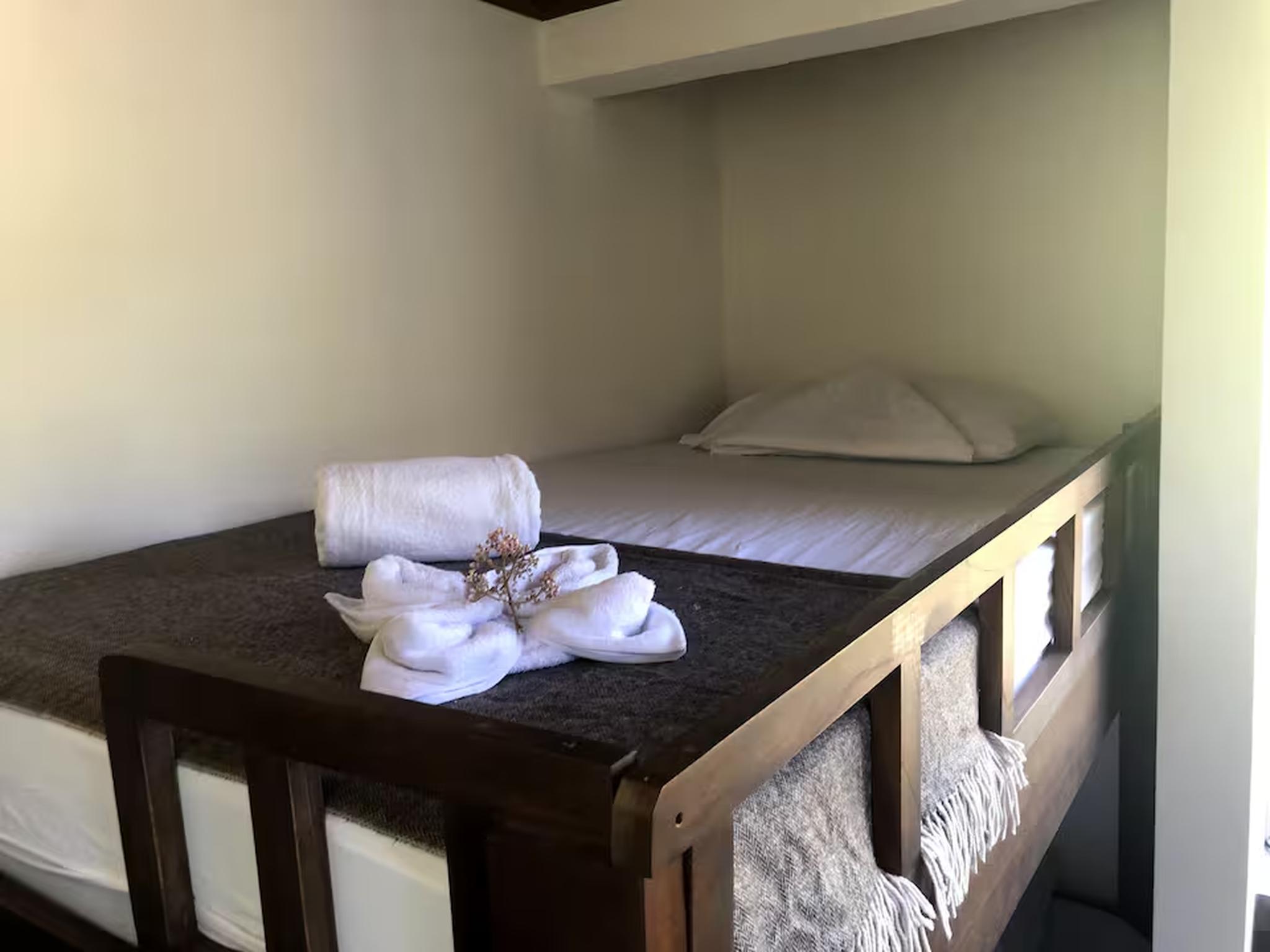 Cozy alcove bed with fresh linens and warm rustic wood accents