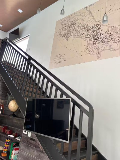 Modern staircase with striking Costa Rica map wall and cozy lounge nook