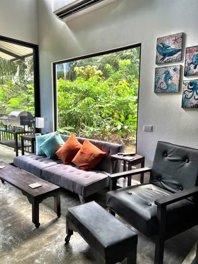 Bright tropical lounge with garden views, AC, and stylish modern seating