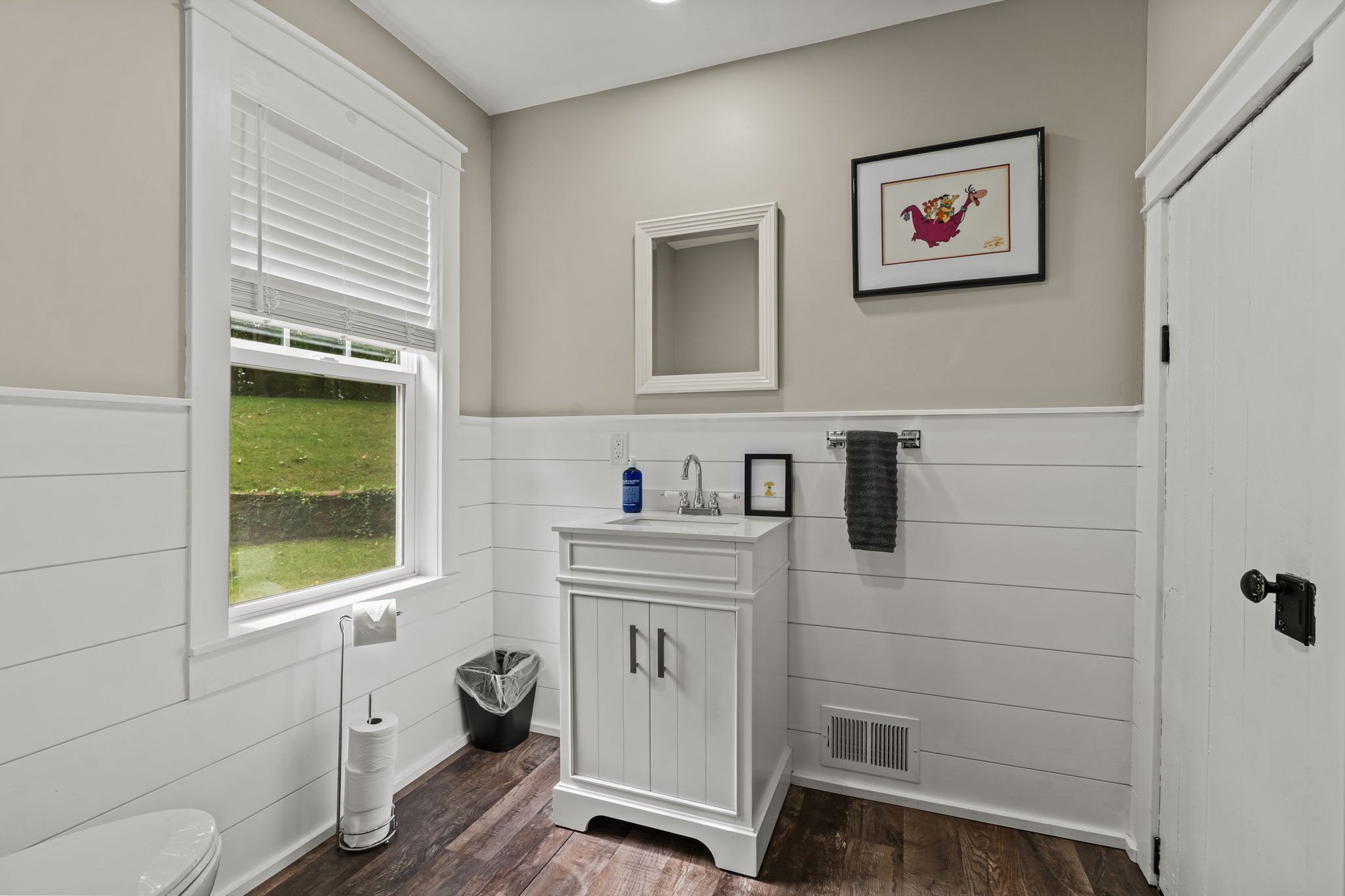 Bright, charming bathroom with shiplap walls and natural light