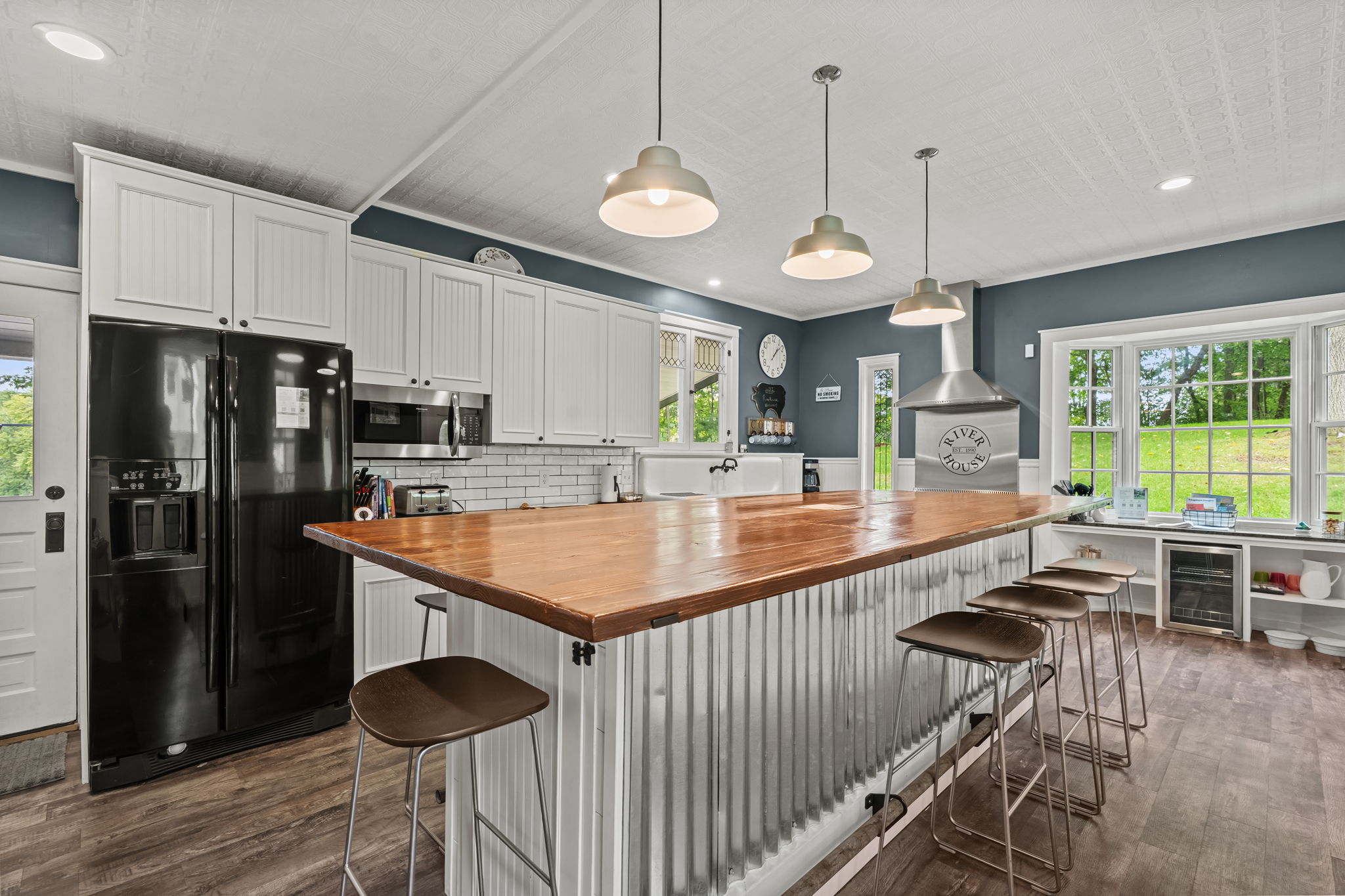 Bright farmhouse kitchen with large island, bar seating, and scenic views