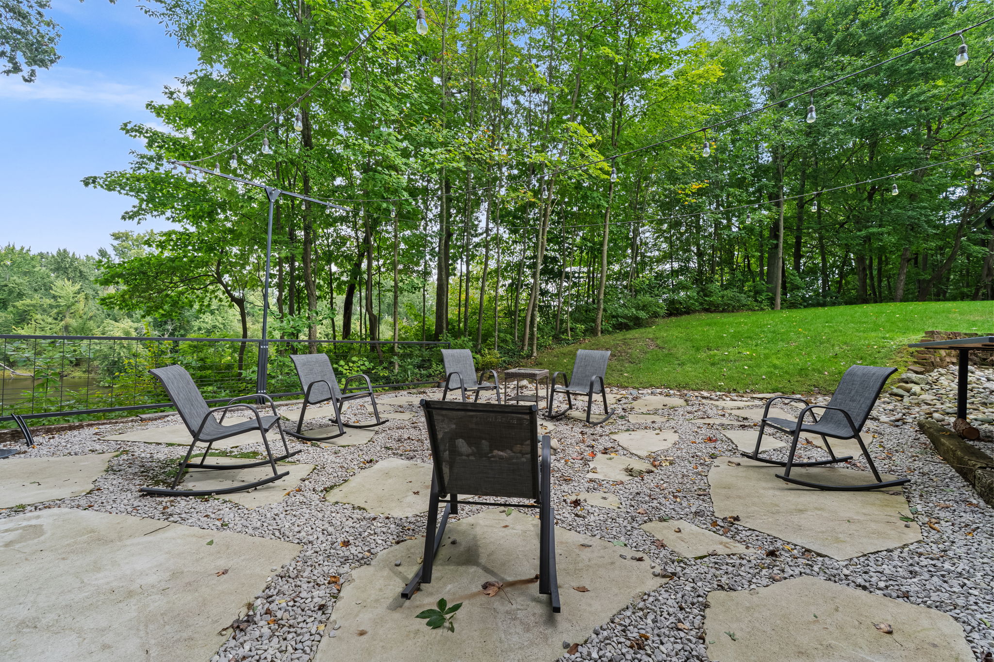Private fire pit patio with rocking chairs and serene wooded views
