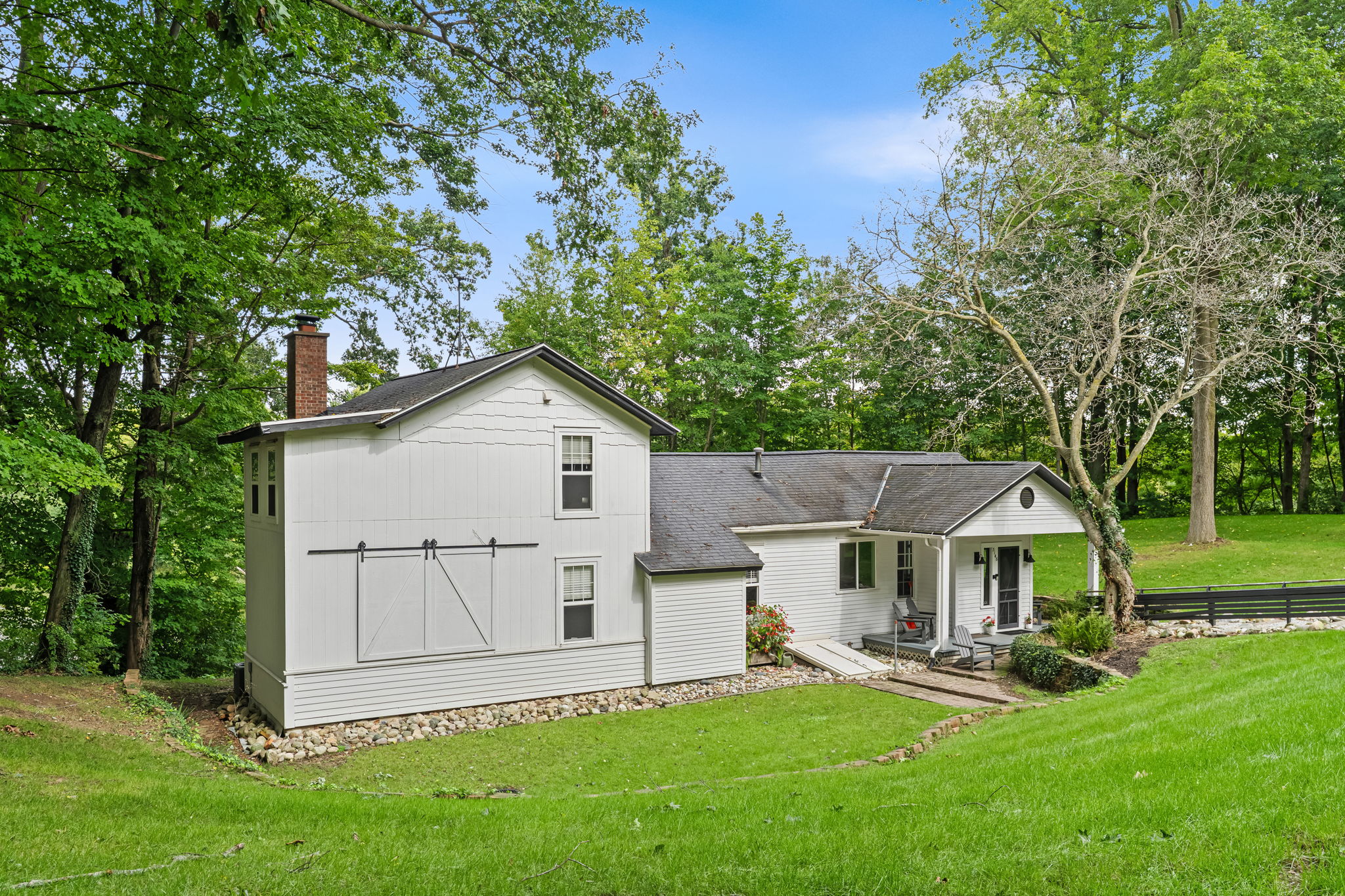 Charming farmhouse retreat with a lush yard and peaceful wooded setting