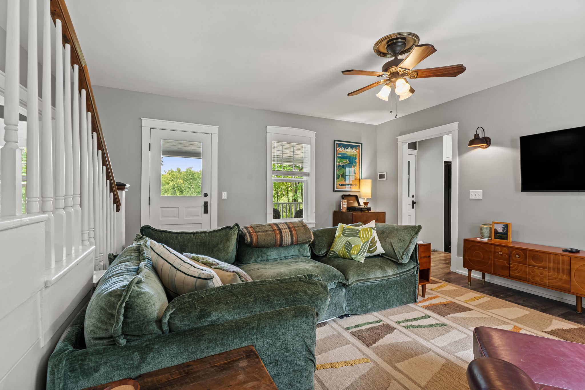 Bright living room with plush sectional, TV, and stylish modern touches