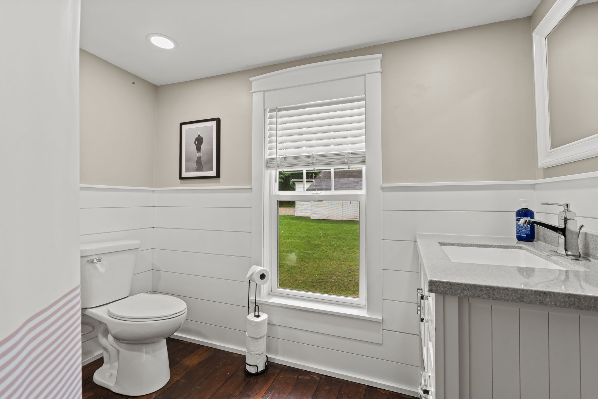 Bright modern bathroom with shiplap walls, natural light, and yard views