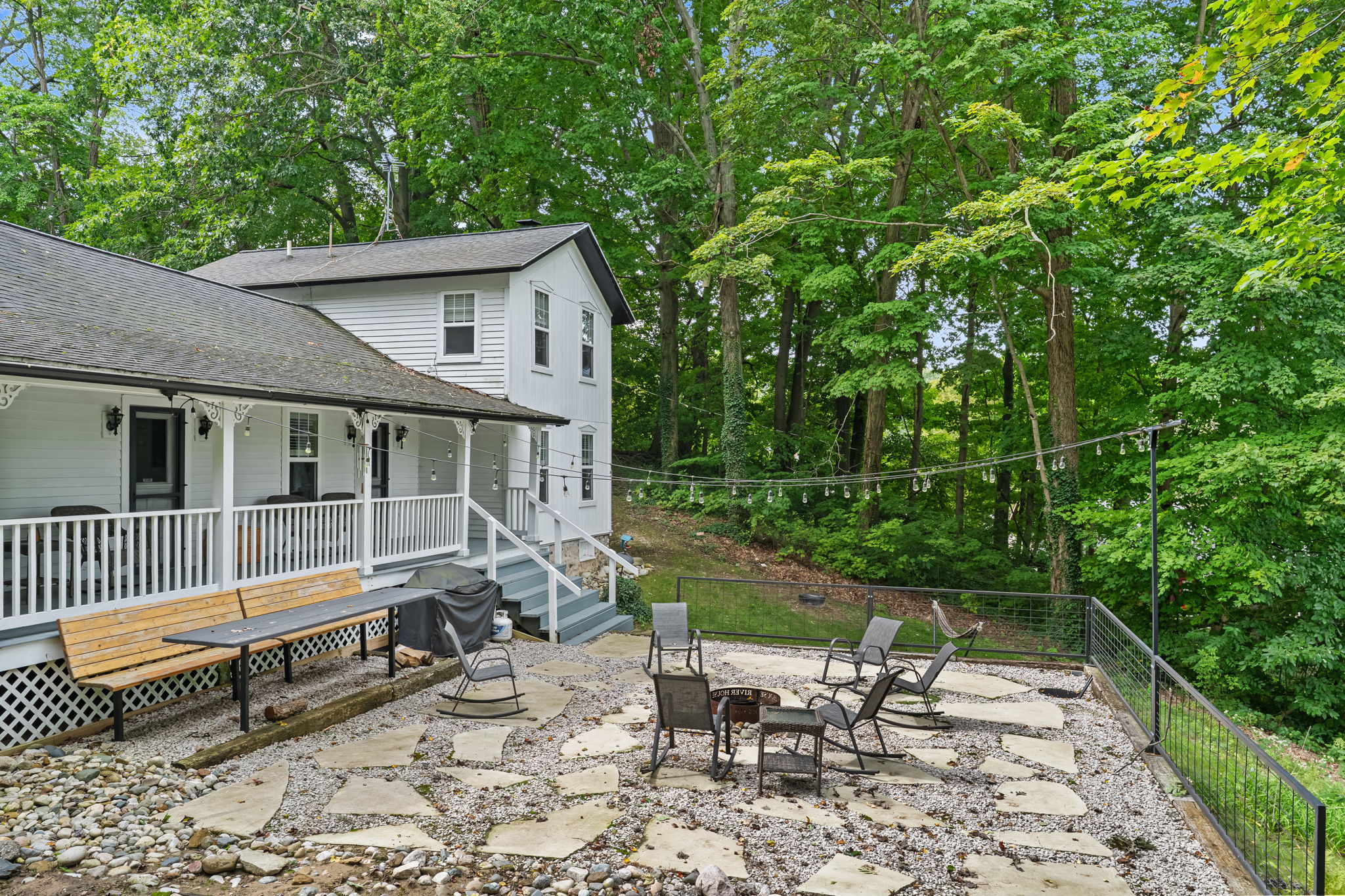 Private wooded patio with fire pit, porch, and cozy outdoor seating