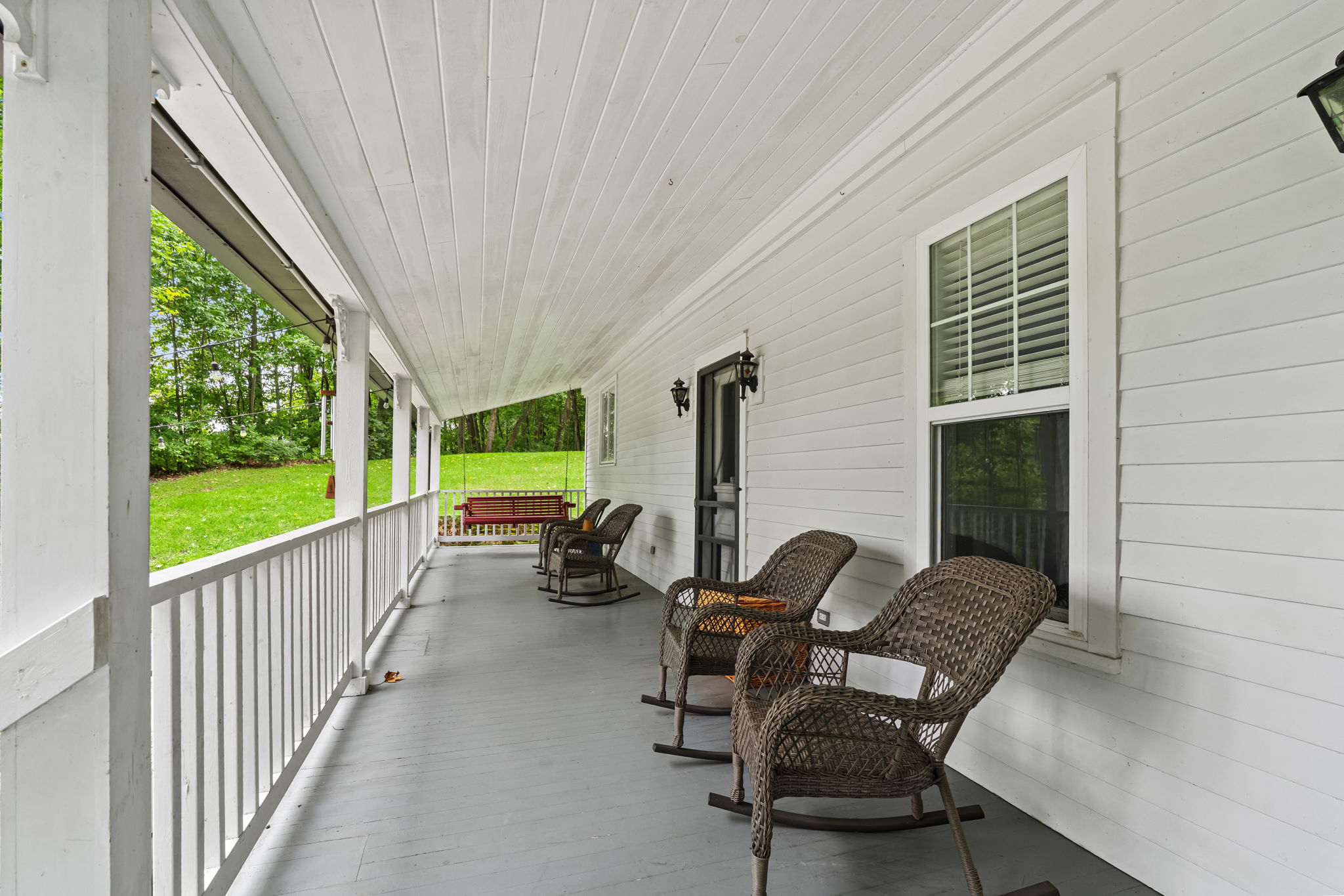Relax on the long covered porch with rocking chairs and a charming swing