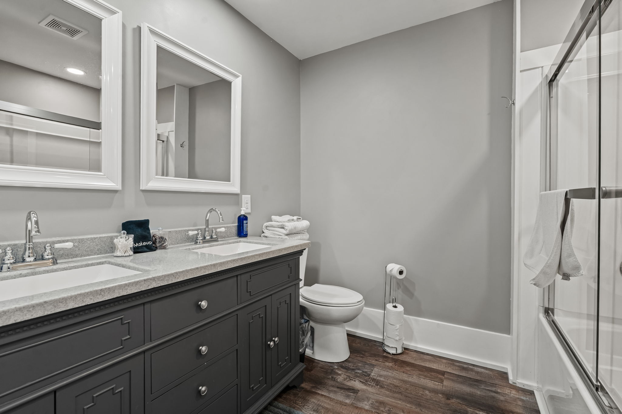 Modern full bath with double vanity and glass-enclosed shower