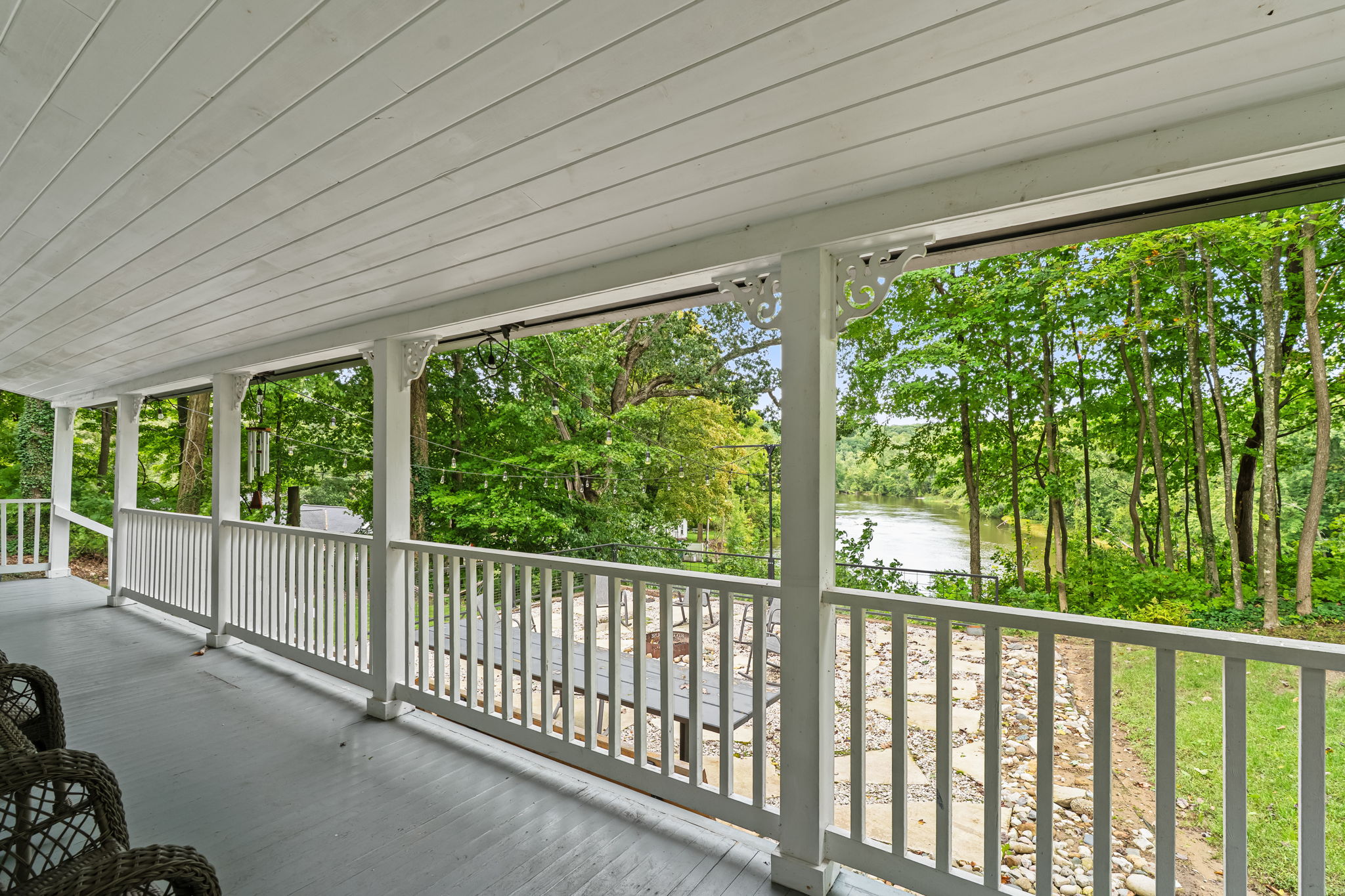 Covered porch with serene river views and peaceful wooded surroundings