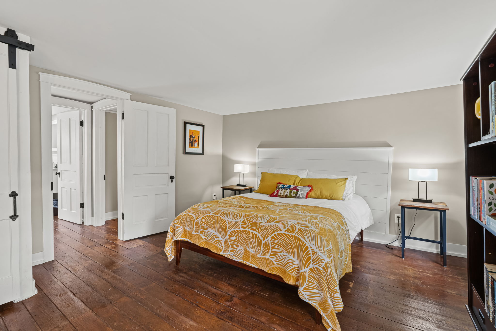 Bright, spacious bedroom with rustic floors and cheerful modern accents
