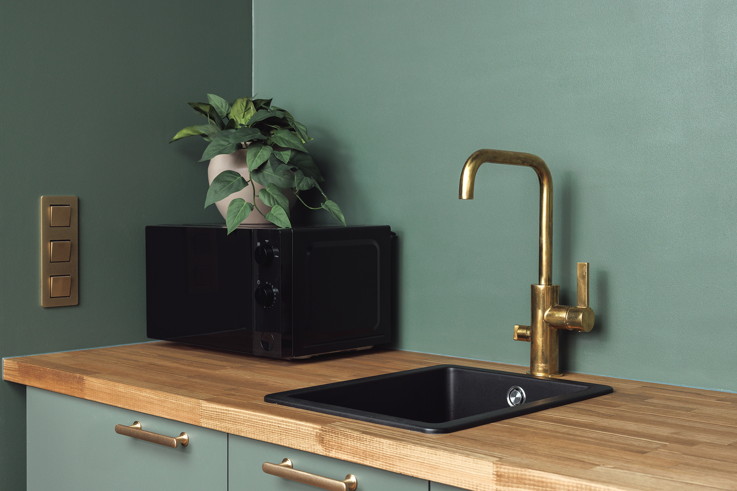 Kompakti keittiö, puutaso ja messinkinen hana