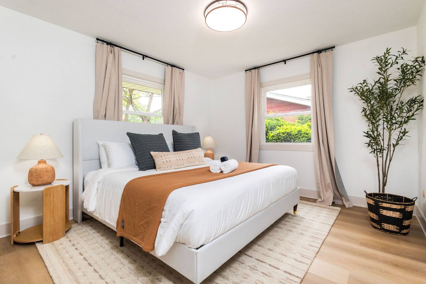 King bedroom with upholstered headboard and caramel throw