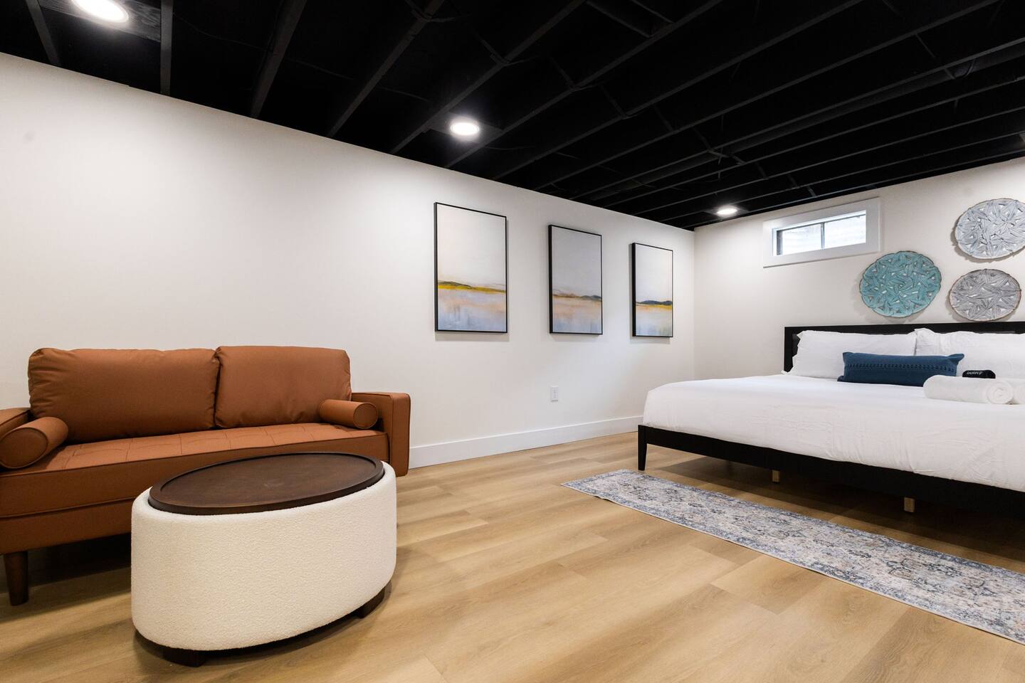 Lower-level lounge with leather sofa next to a bedroom