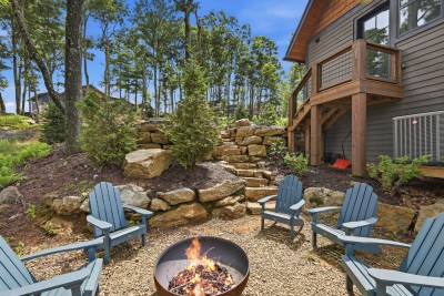 Wooded fire pit patio with Adirondack chairs and private deck access