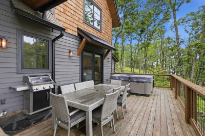 Your private wooded deck features a hot tub, grill, and dining for six — the perfect spot to unwind, cook outdoors, and soak in the mountain air surrounded by trees.