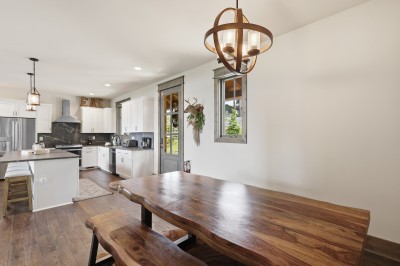 Bright farmhouse kitchen and dining space featuring a rustic wood table — warm, welcoming, and perfect for shared meals.