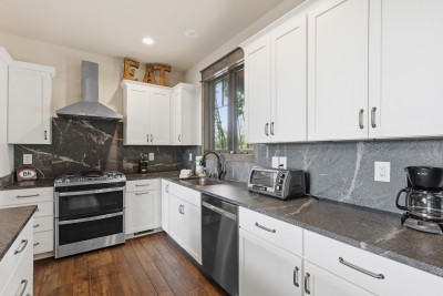Bright modern kitchen featuring stainless steel appliances, stylish finishes, and an open layout that flows effortlessly into the living space — perfect for cooking and gathering.