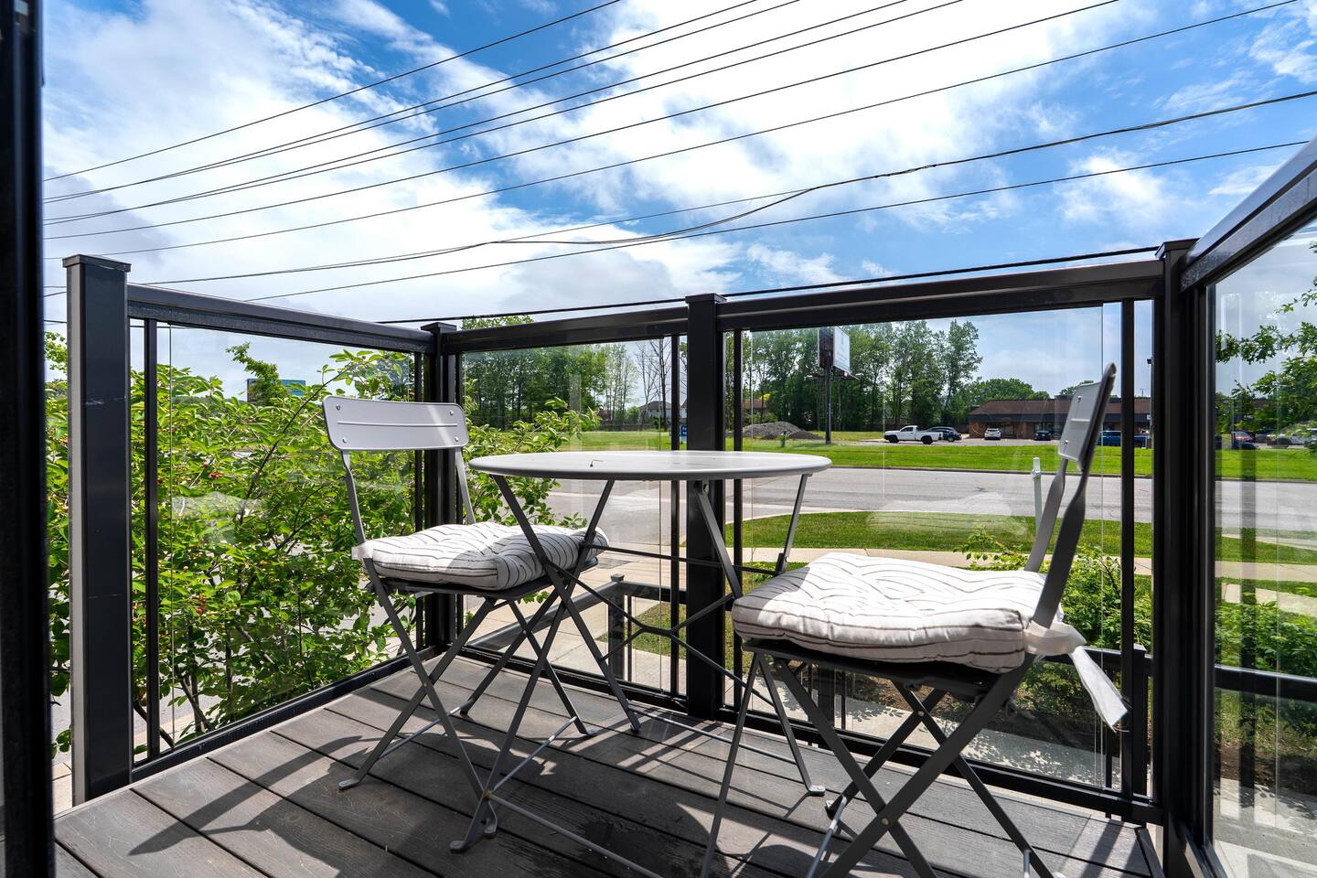 Private balcony with cushioned bistro seating and open outdoor views, creating a pleasant spot for fresh air and quiet moments.