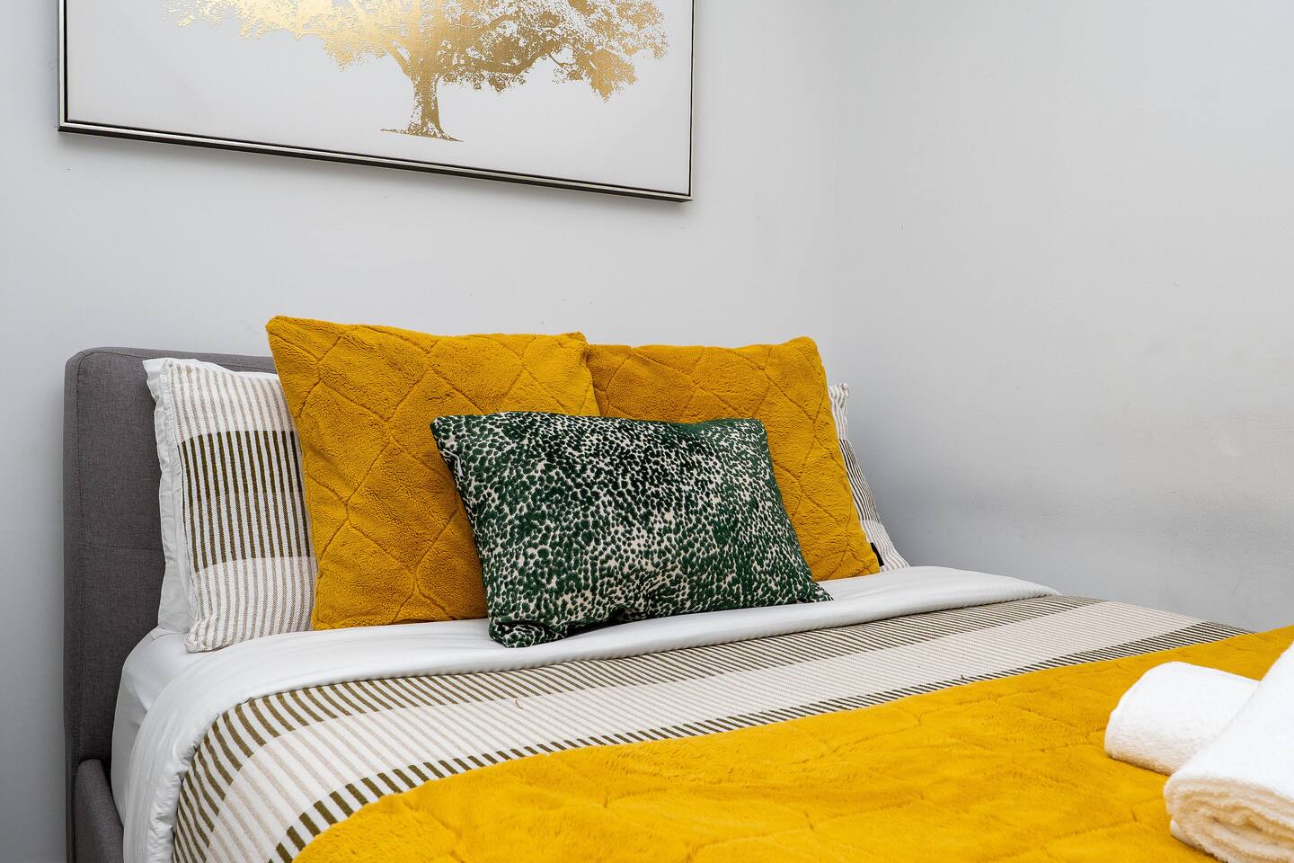 Close-up of layered pillows and warm bedding, adding a comfortable and inviting feel to the bedroom.