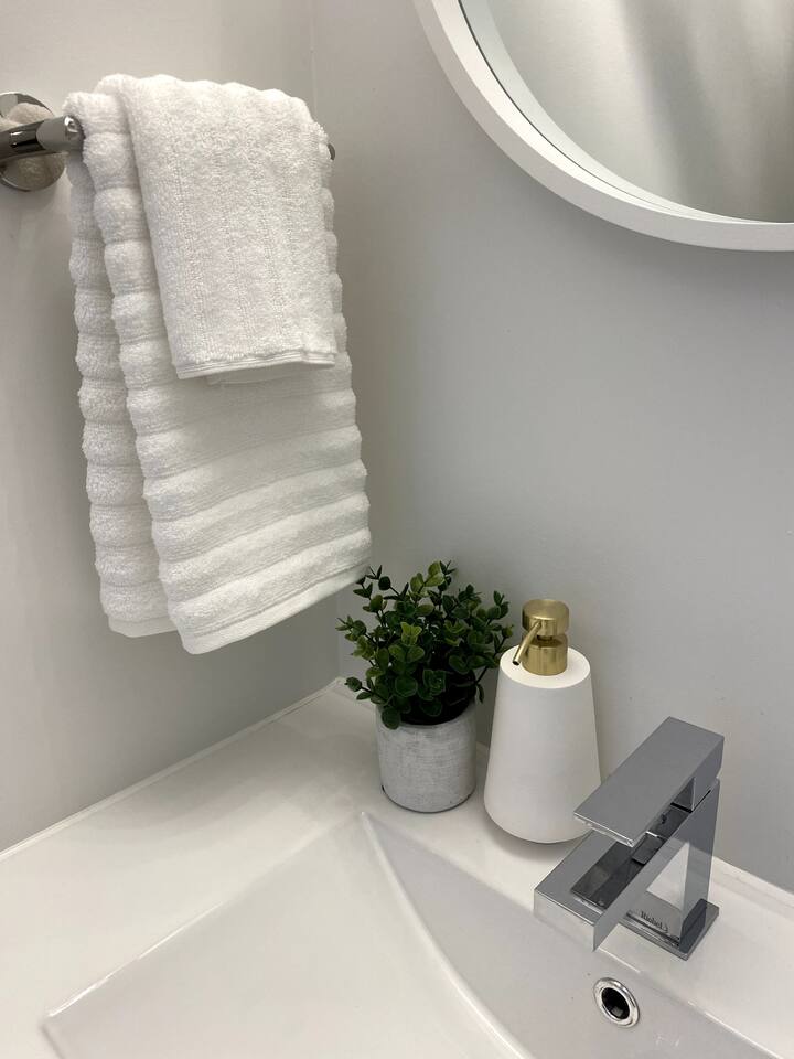 Clean bathroom vanity with fresh towels, a modern faucet, and simple decor for a bright, refreshed start to the day.