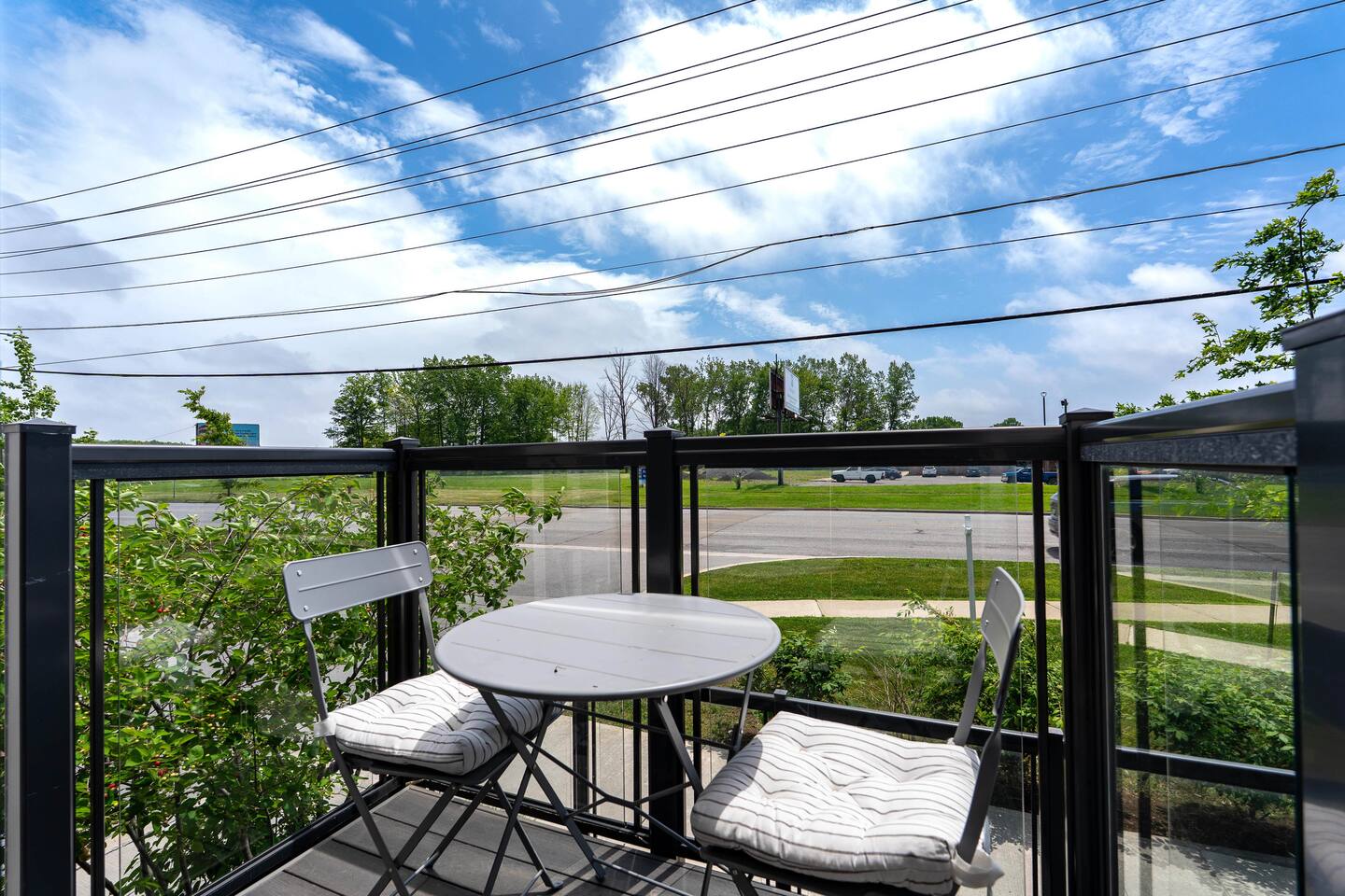 Private balcony with bistro seating and open views, offering a bright spot to enjoy fresh air and relax outdoors.