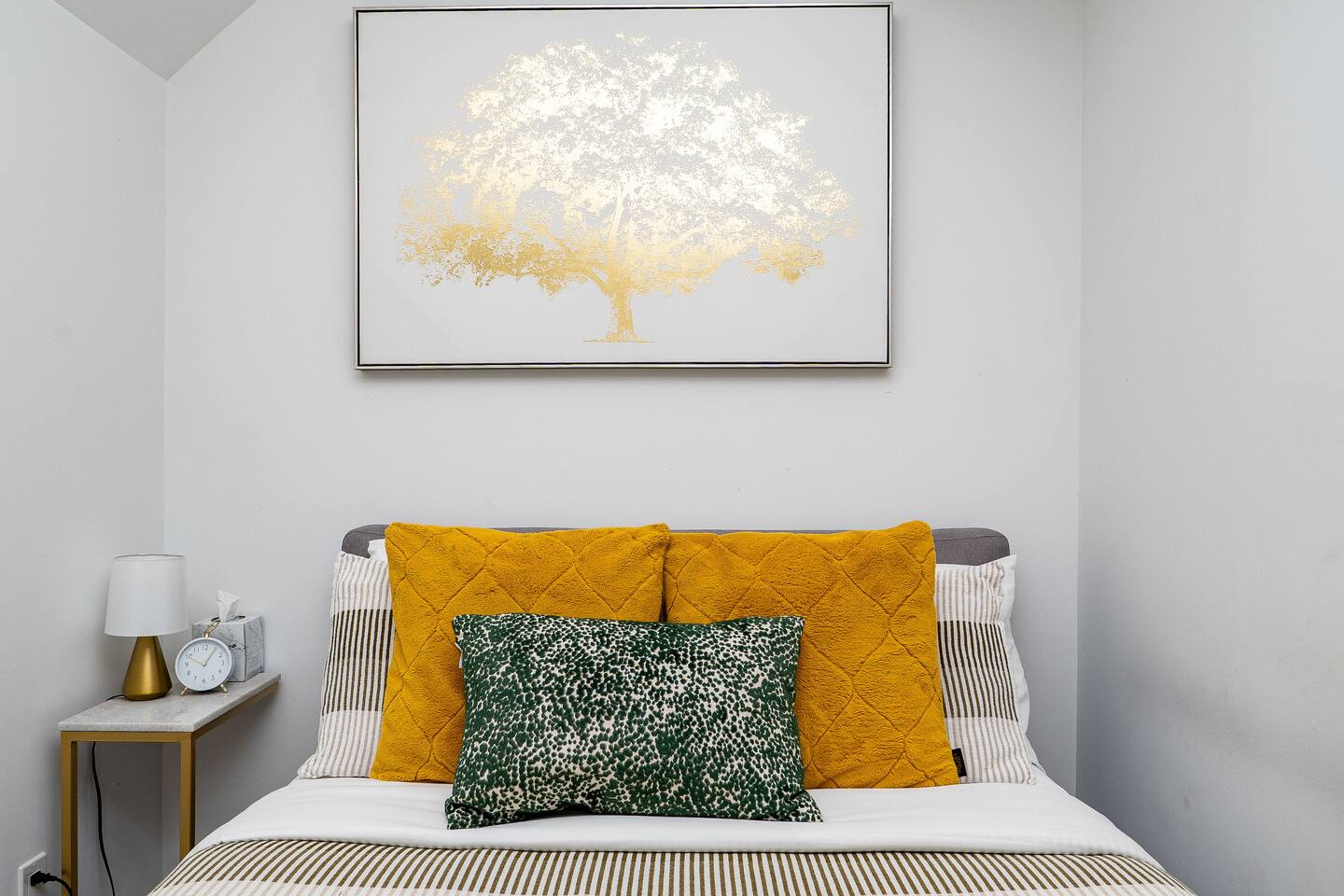 Cozy seating nook with bold accent pillows, soft textures, and elegant wall art, creating a calm spot to relax indoors.