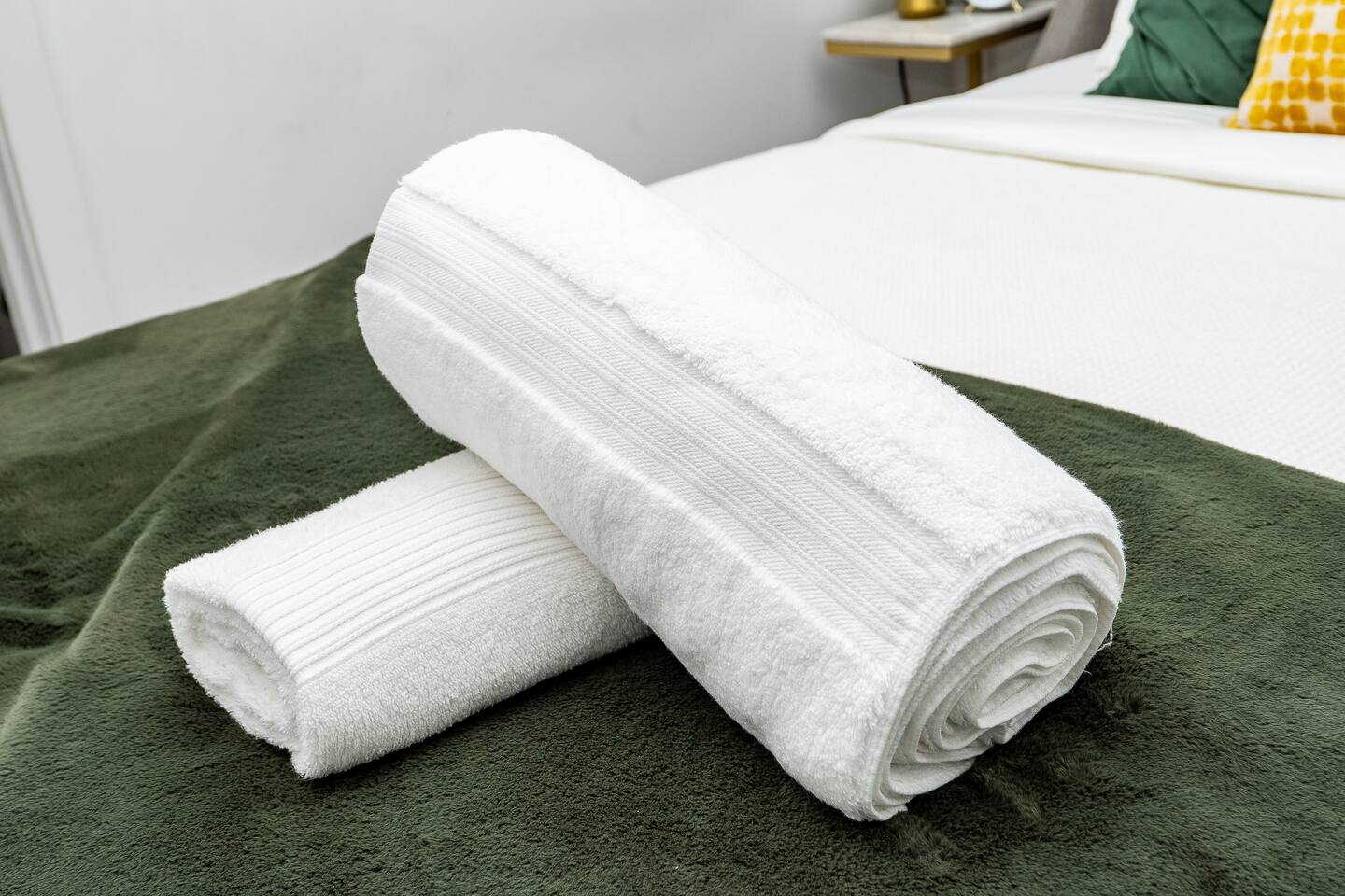 Fresh towels neatly placed on the bed, adding a clean and welcoming touch for a comfortable stay.