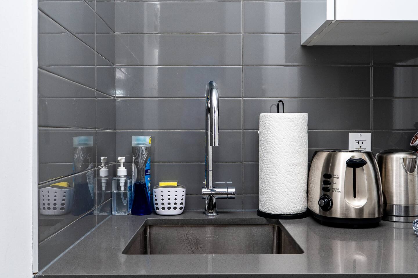 Compact kitchen sink area with cleaning essentials and countertop appliances, keeping the space practical and easy to use during your stay.