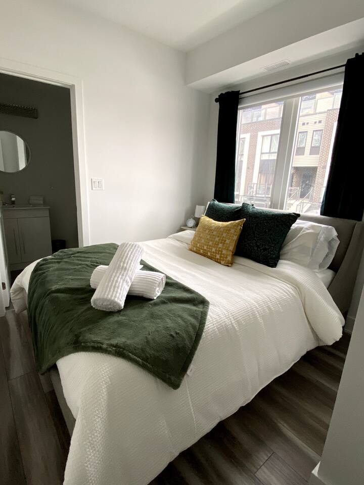 Extra towels availableBright bedroom with fresh linens, soft green accents, and natural light, offering a comfortable place to rest during your stay.