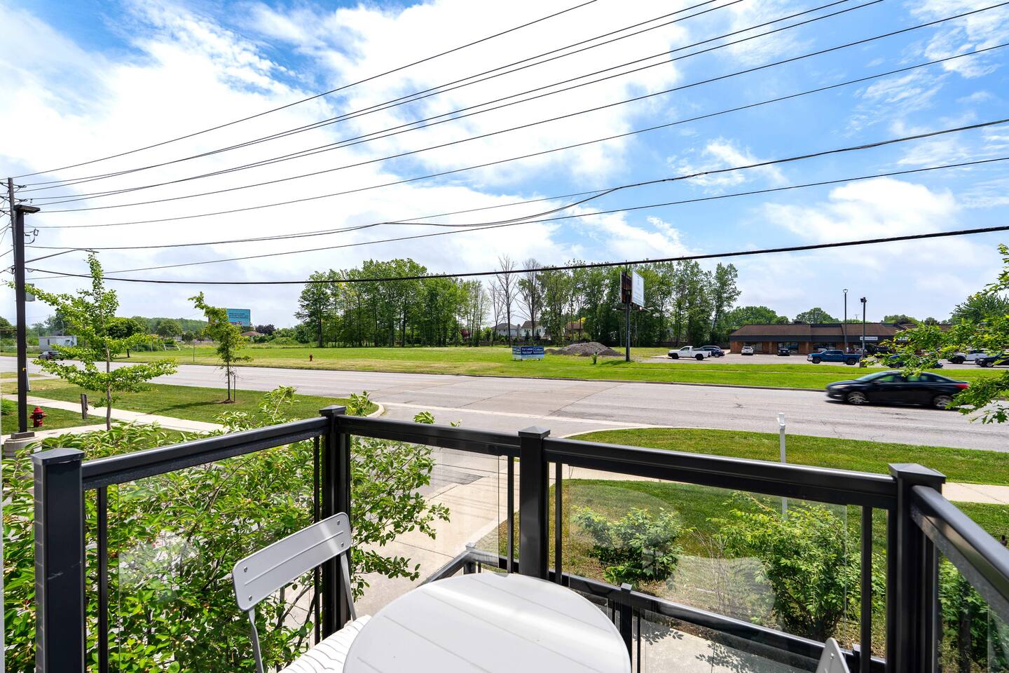 Balcony seating with open neighborhood views and greenery, offering a quiet spot to enjoy fresh air and the outdoors.