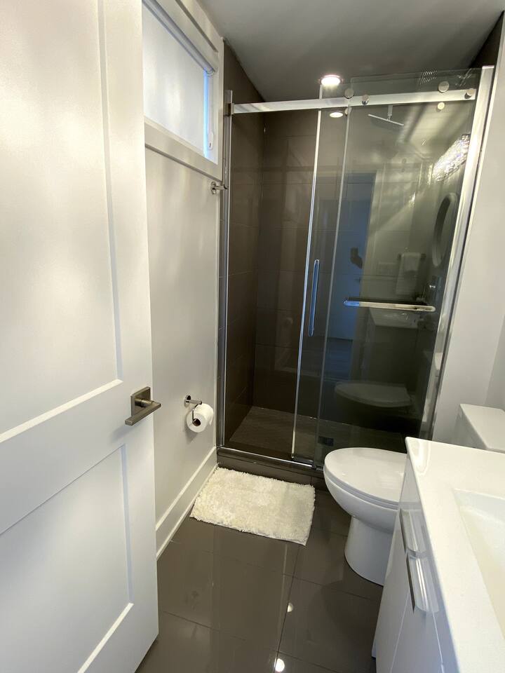 Clean bathroom with a glass shower, fresh towels, and modern finishes, providing a bright and practical space for daily routines.