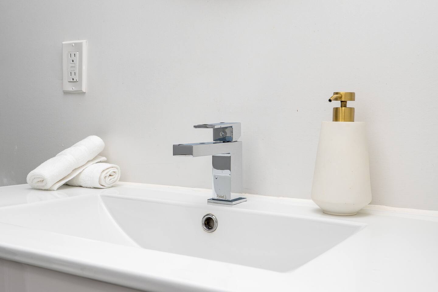 Clean bathroom sink with a modern faucet, fresh towels, and simple essentials for a comfortable daily routine.