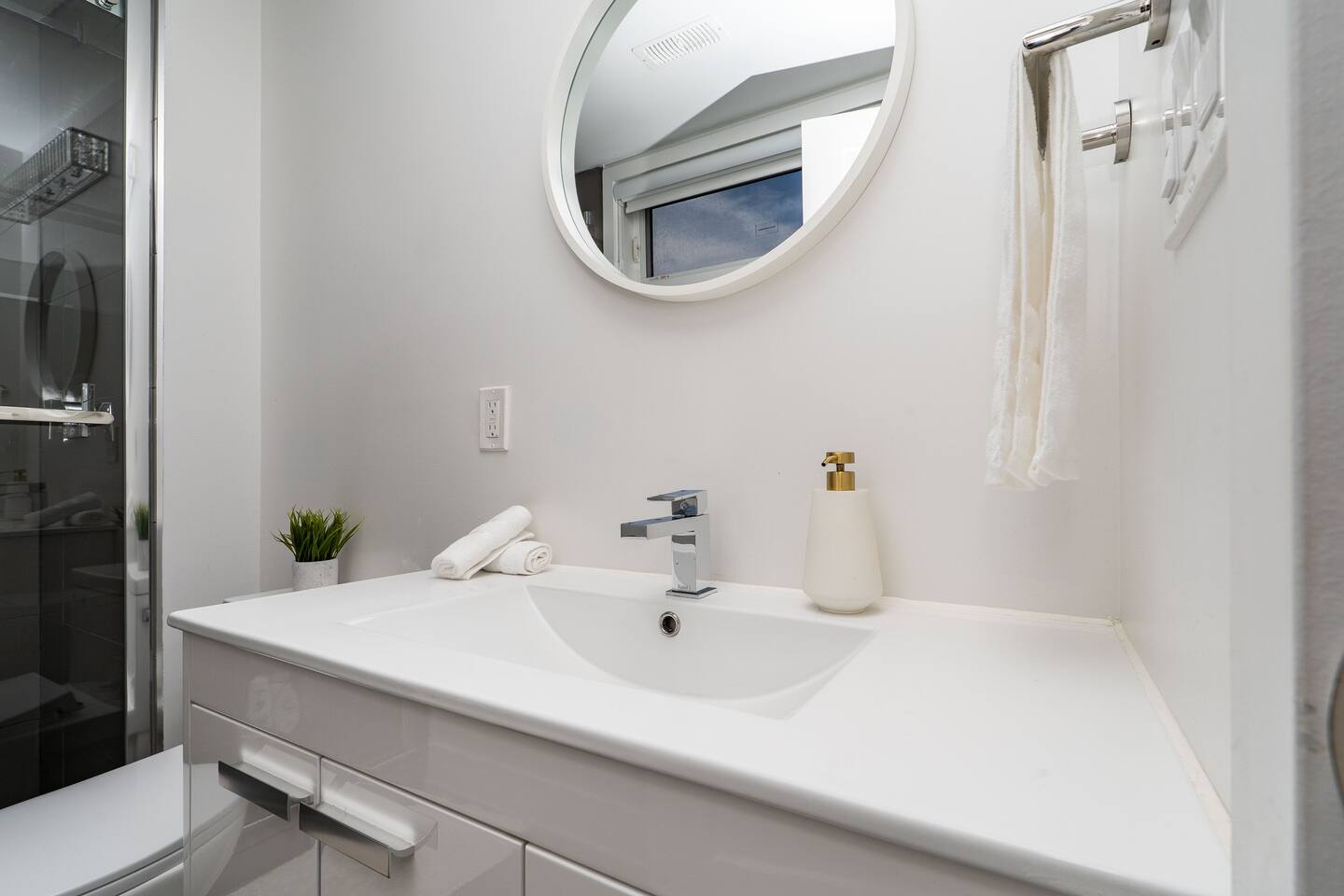 Clean bathroom vanity with a round mirror, fresh towels, and simple essentials for an easy daily routine.
