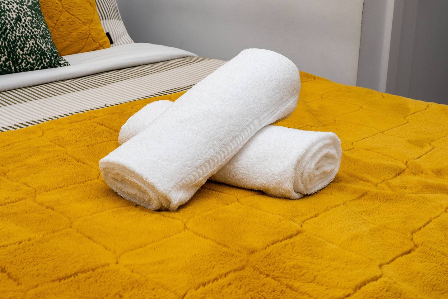 Fresh towels placed on the bed, adding a clean and welcoming touch for guests upon arrival.
