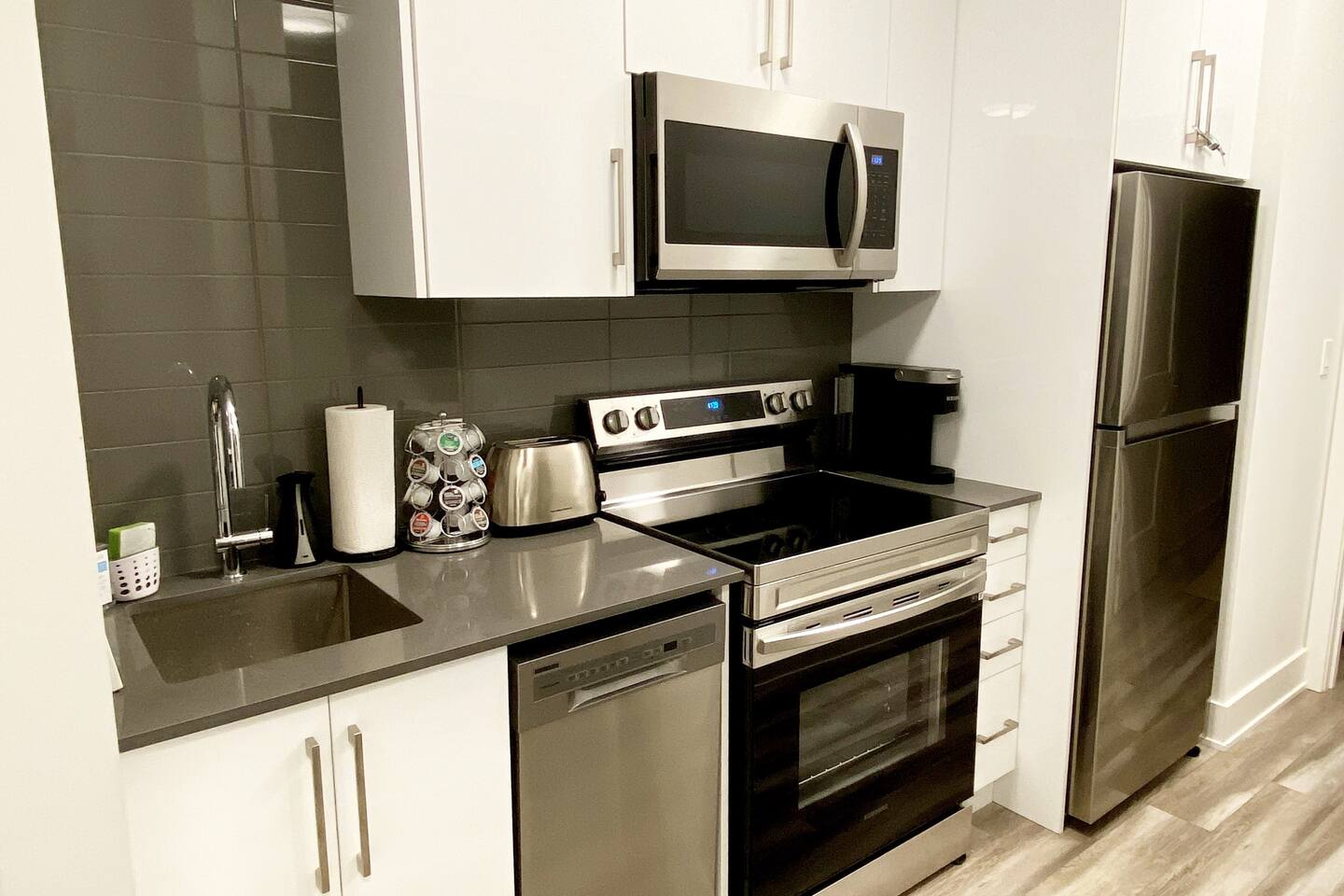 Compact kitchen with stainless steel appliances, microwave, dishwasher, and coffee station for easy meals and everyday convenience.