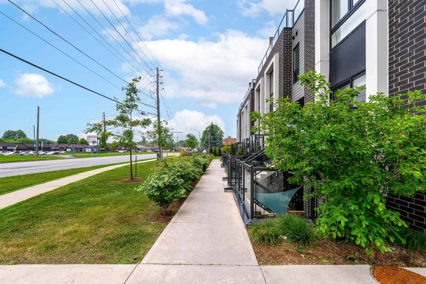 Exterior walkway with greenery and private balconies, offering a welcoming approach to the home and easy outdoor access.