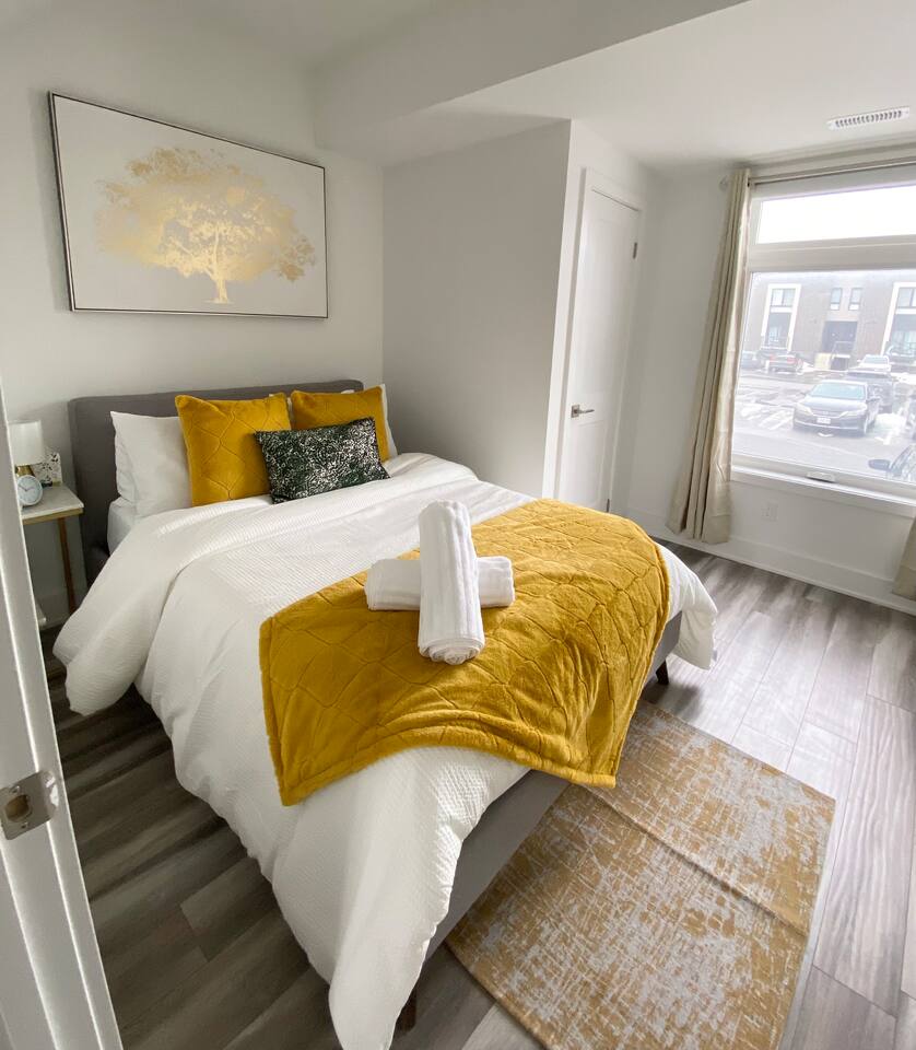 Bright and inviting bedroom with a large window, fresh linens, and warm accents, creating a comfortable retreat after a day of exploring.