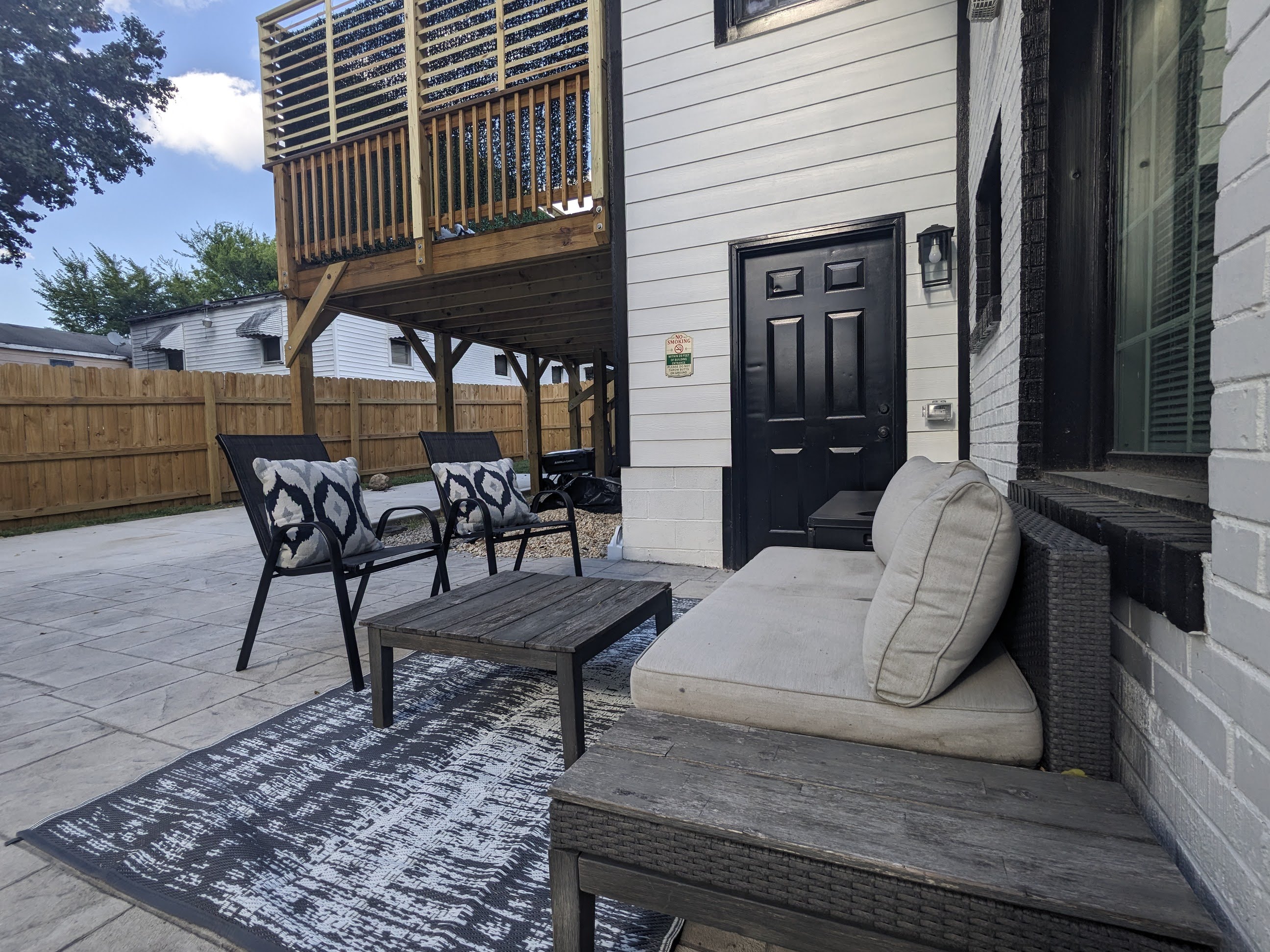 Private fenced patio with cozy seating and bonus upper deck access