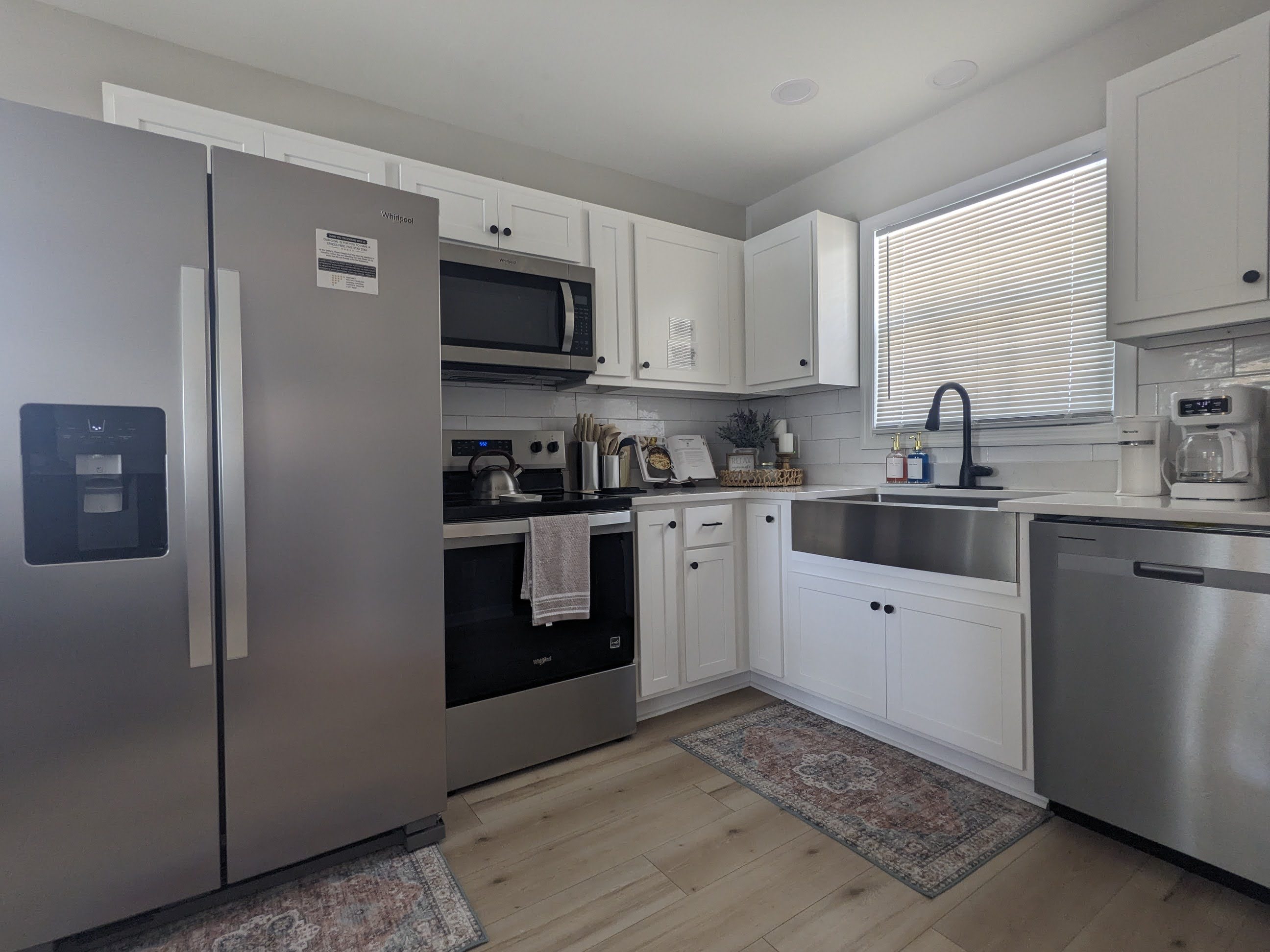 Bright modern kitchen with farmhouse sink and stainless appliances