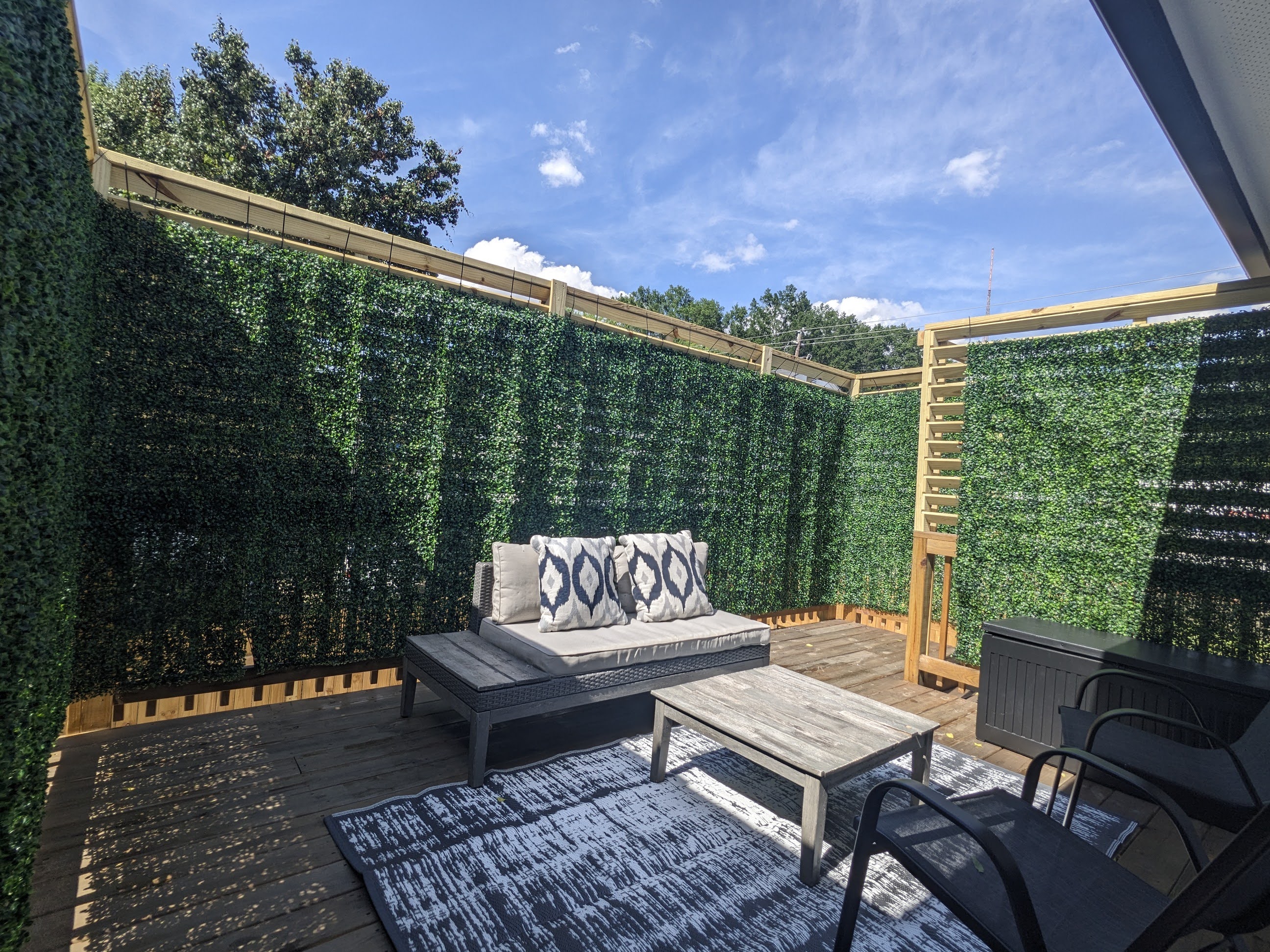 Private outdoor patio with cozy seating and lush privacy walls