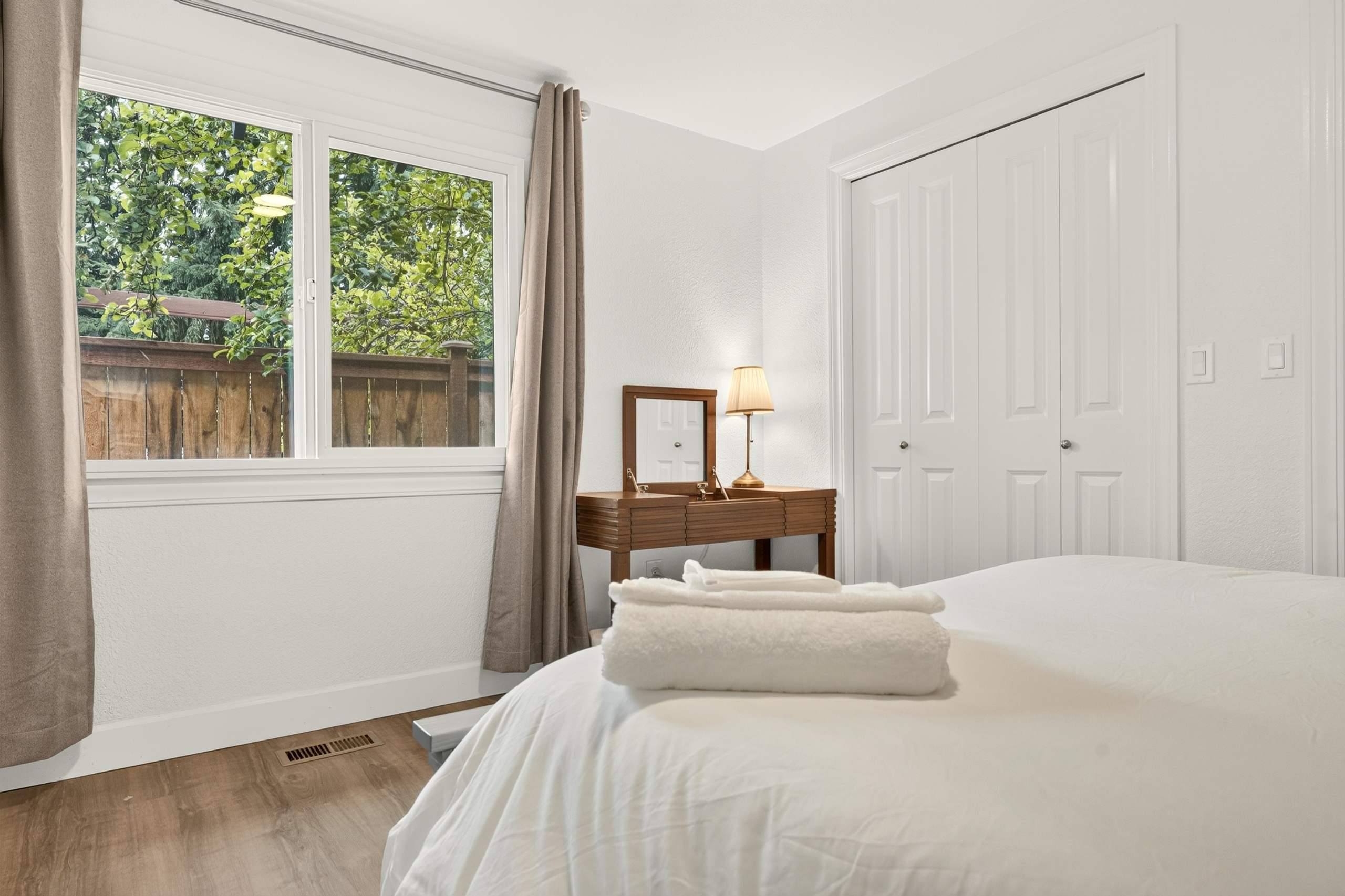 Bright, peaceful bedroom with natural light, closet space, and outdoor views